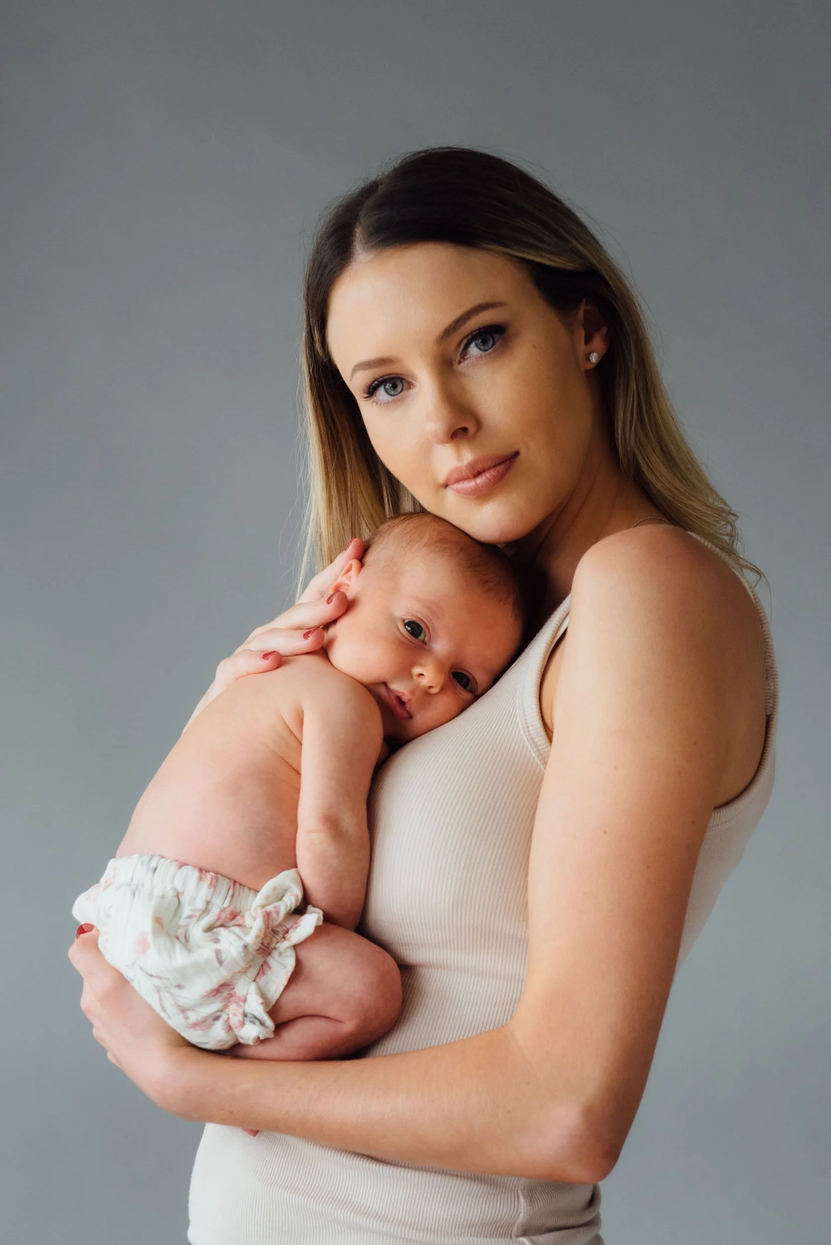 baby photography of mother cuddling her daughter