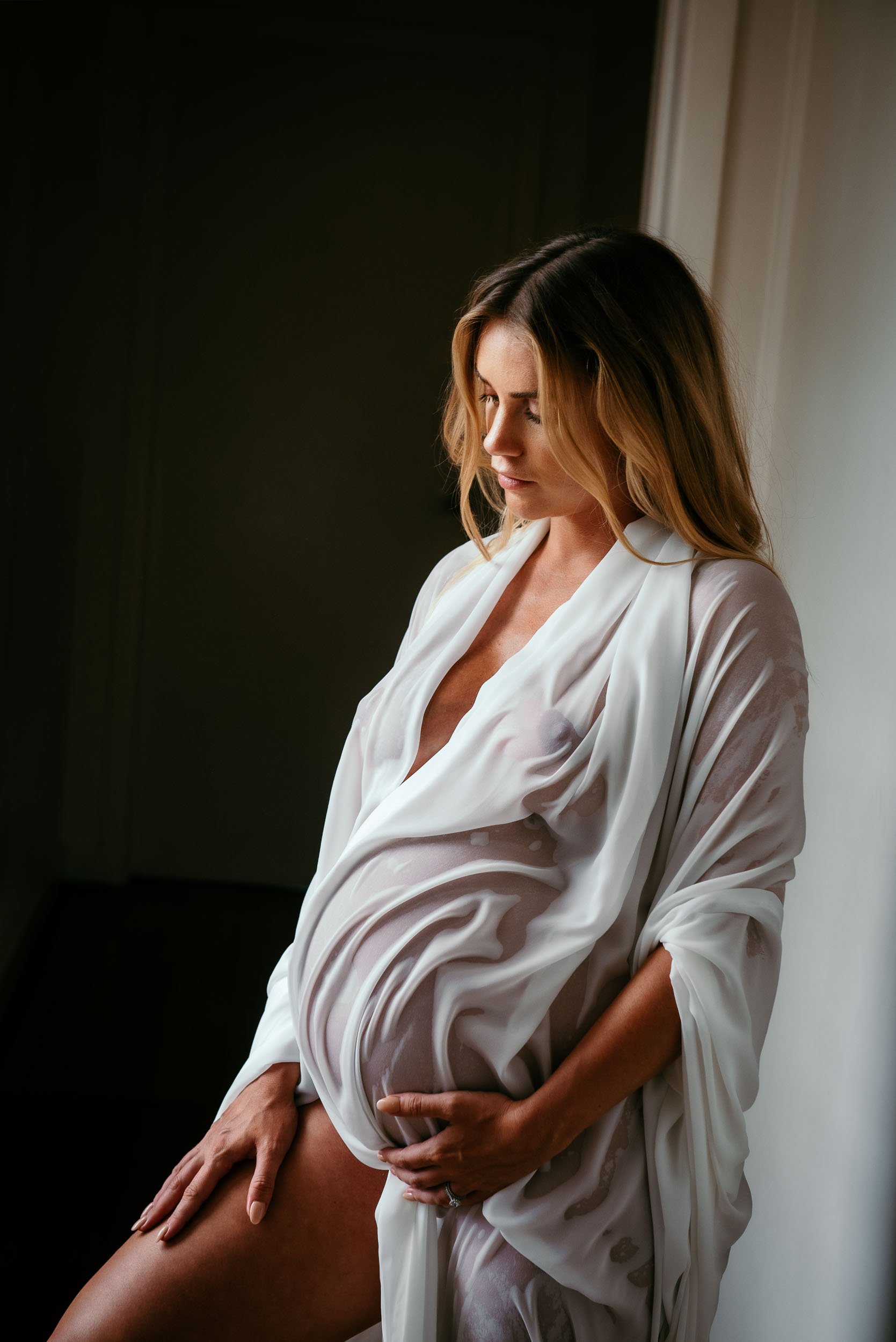 maternity photography of woman draped in wet chiffon material