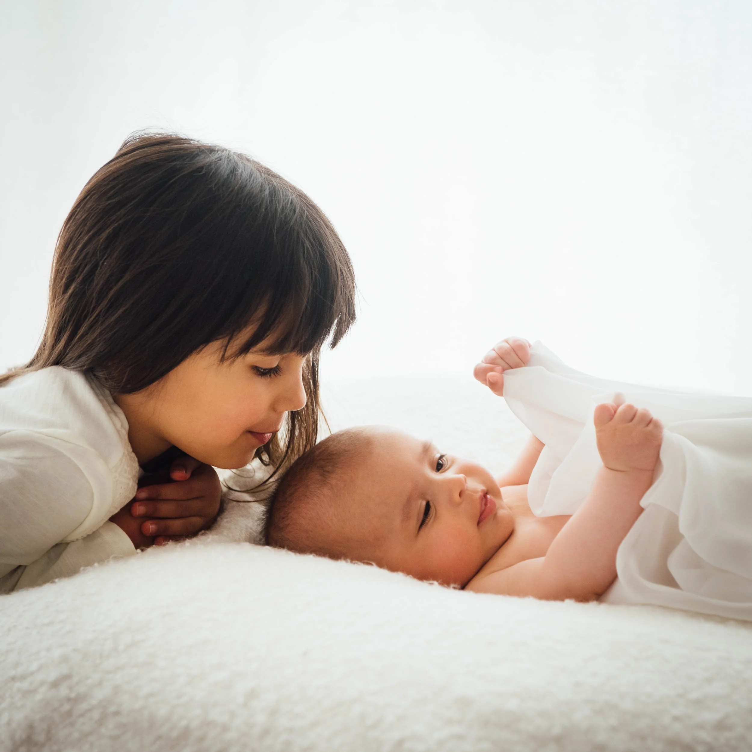 family baby photography of girl looking at her baby brother