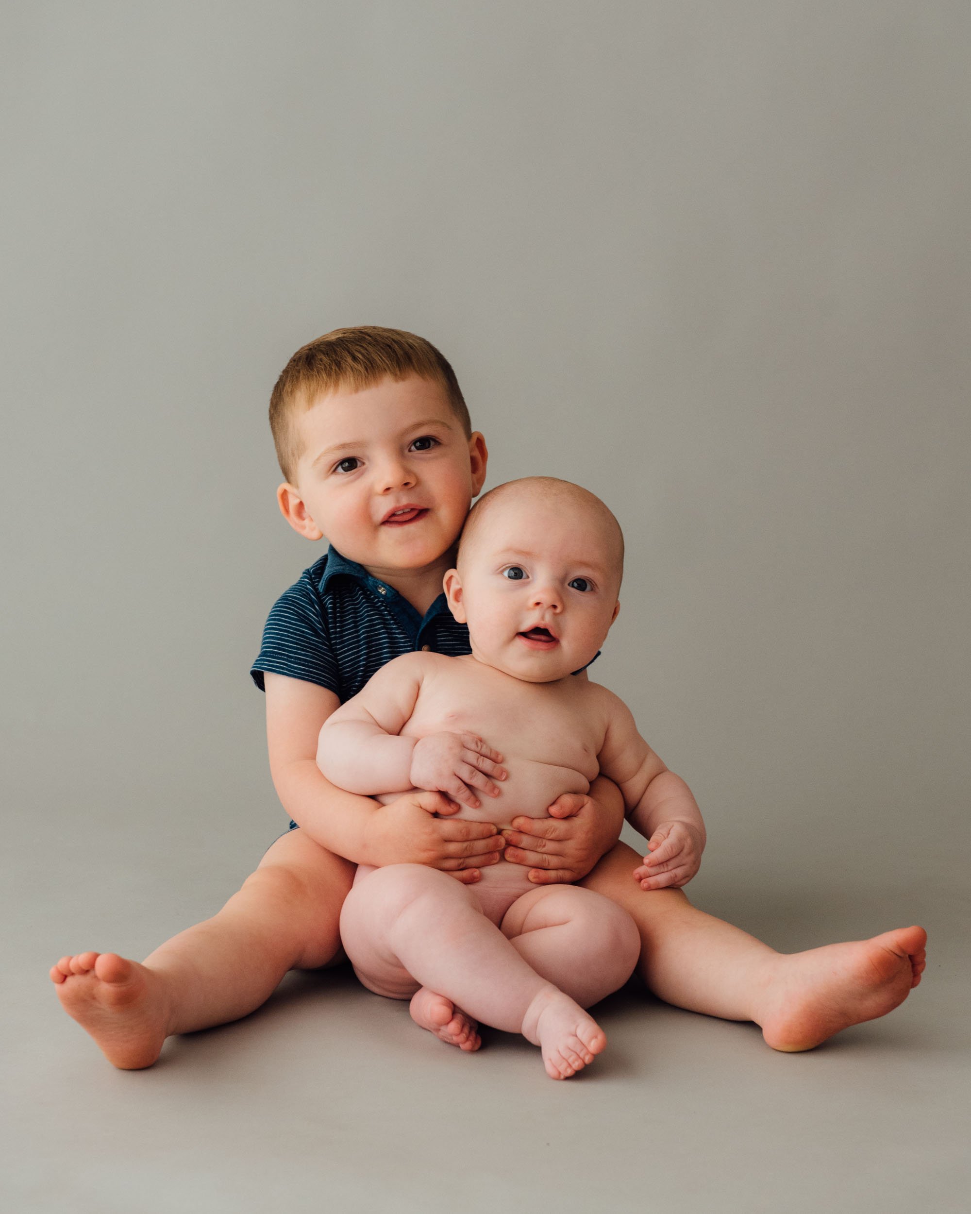 boy cuddling his baby brother