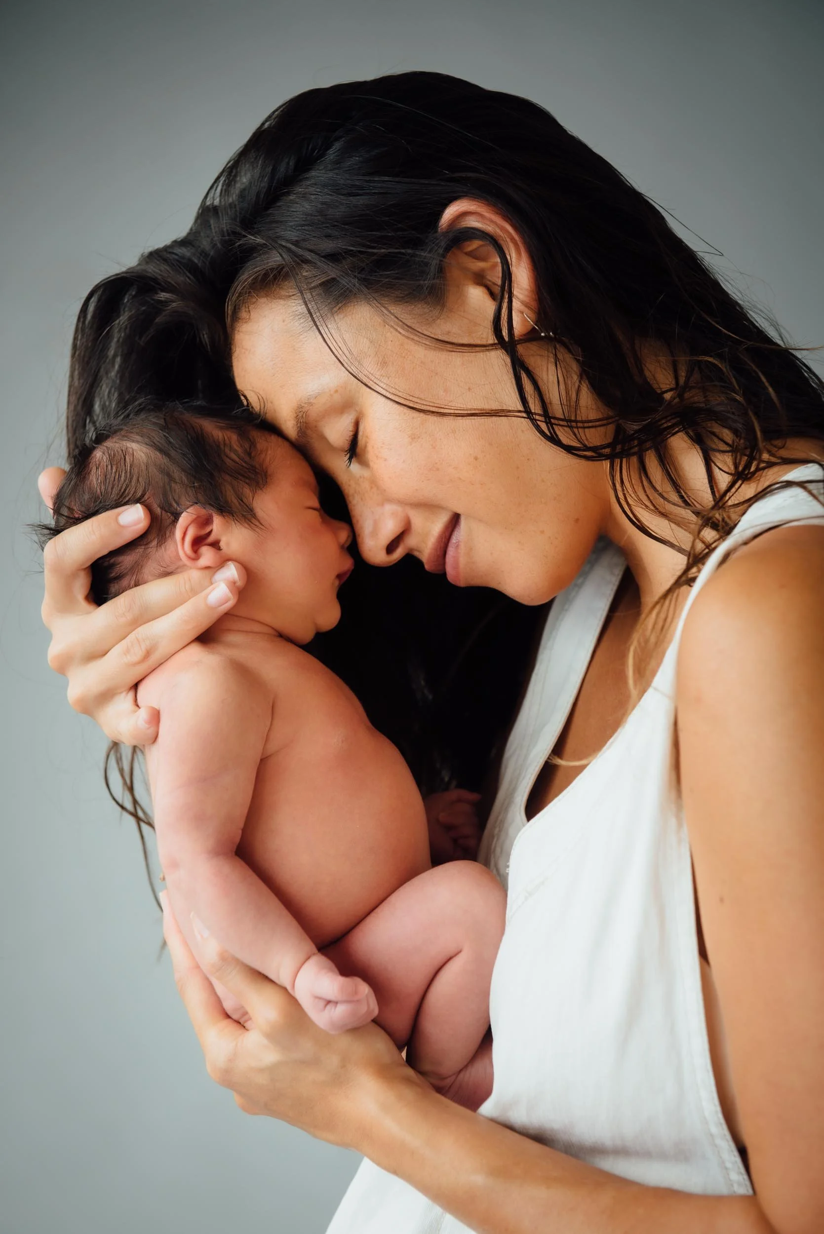 mother cuddling her newborn baby