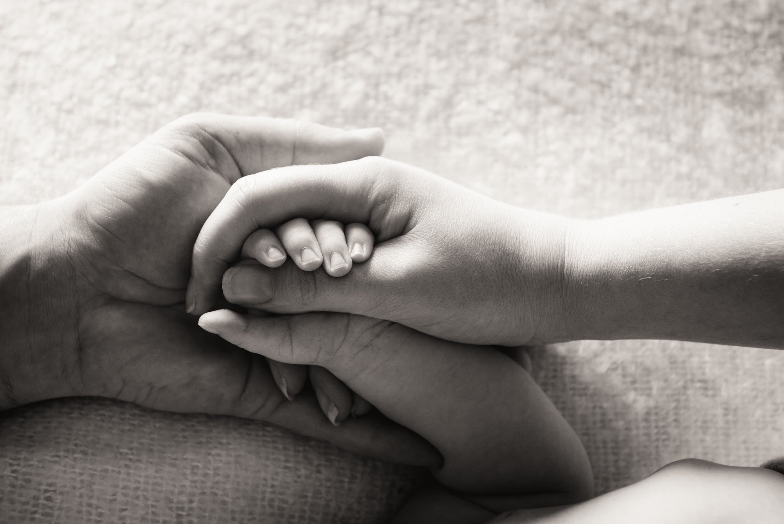 photography of parents holding baby hands close up