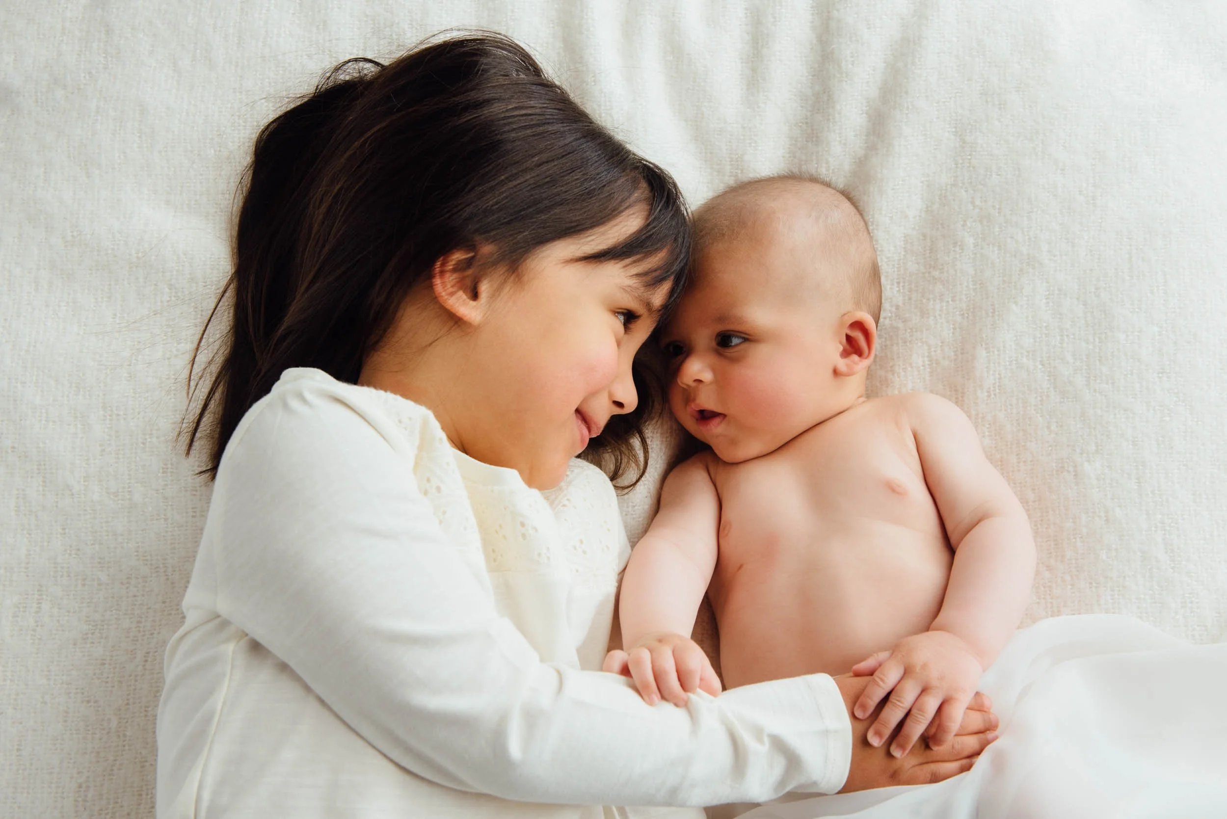 sister cuddling her baby brother