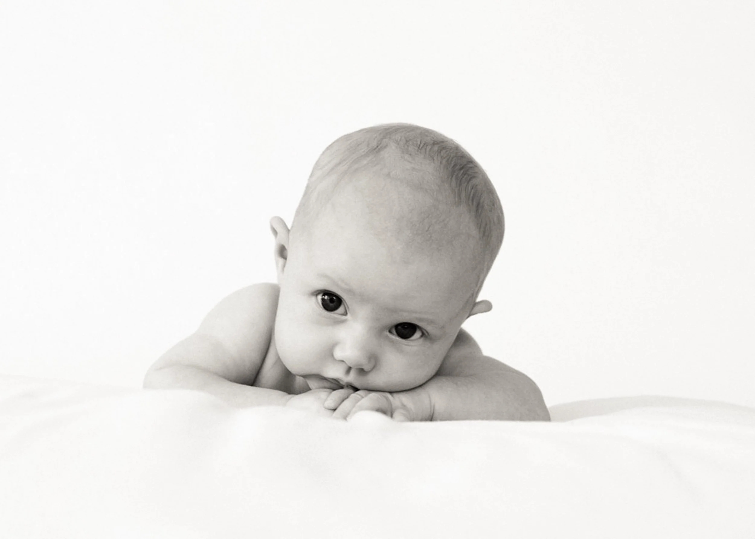 black and white baby photography portrait of 4 month old lying on his tummy