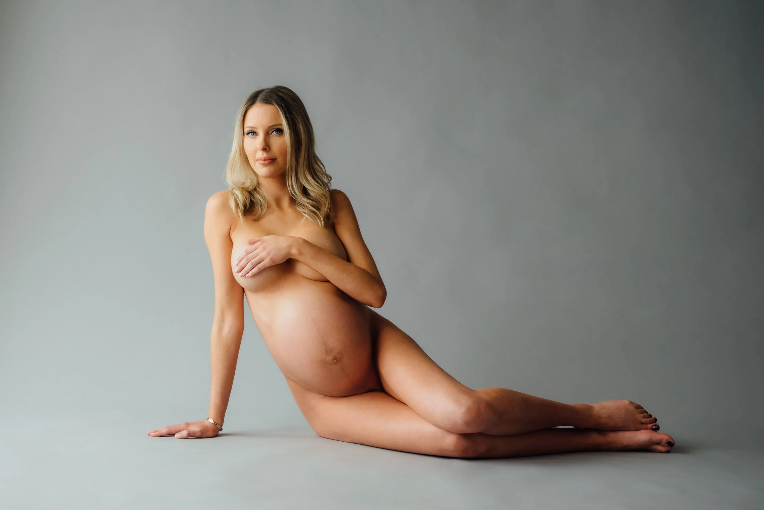 Maternity photoshoot of a woman lying on floor