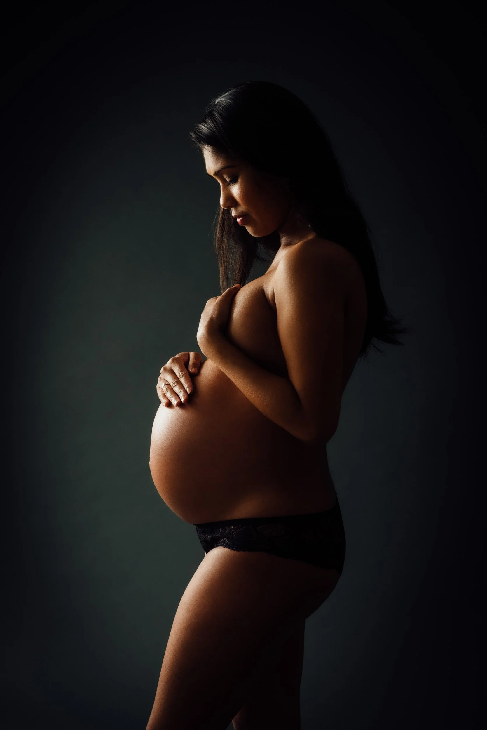 maternity photography shoot of a woman with hands on belly