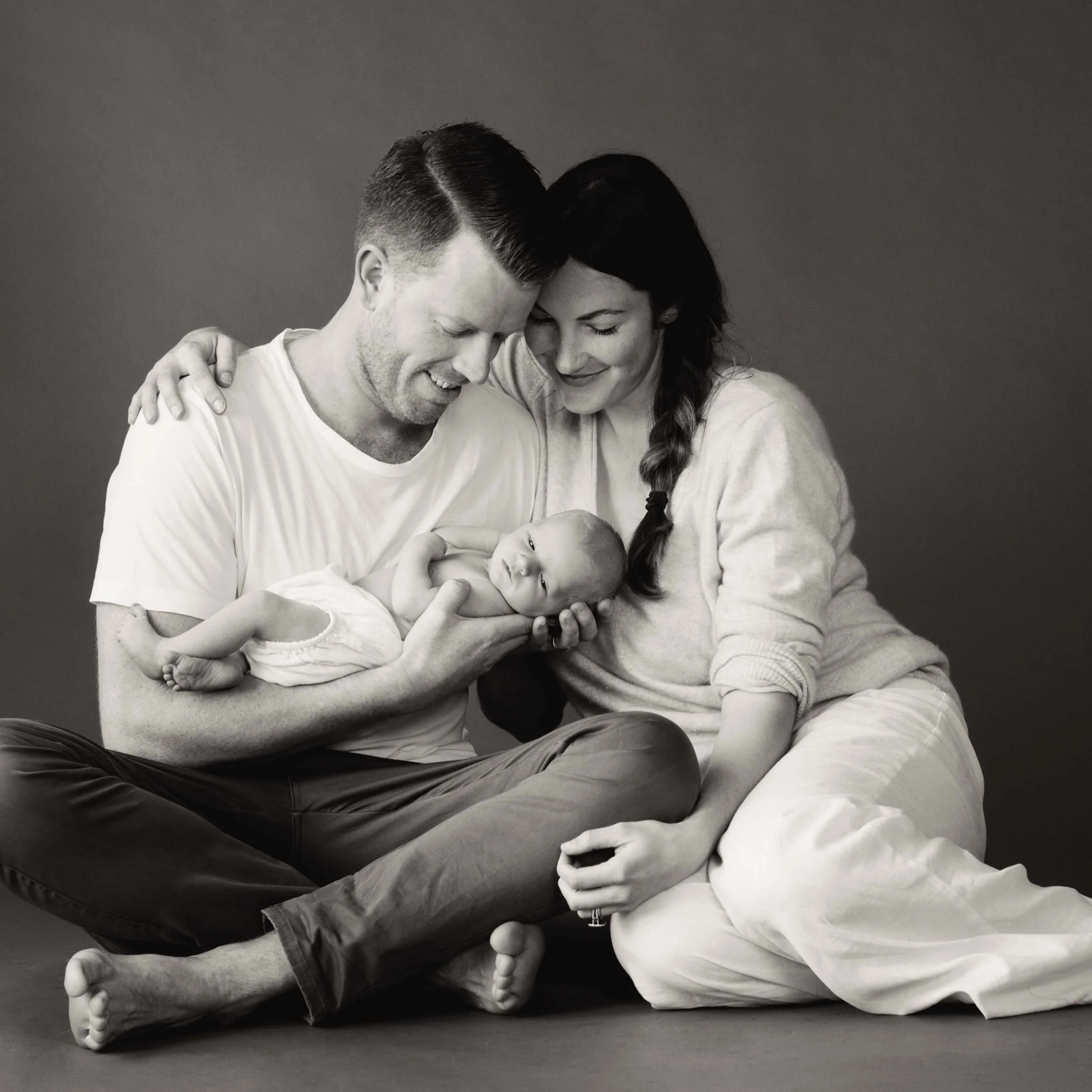 family newborn photography session of parents holding their son