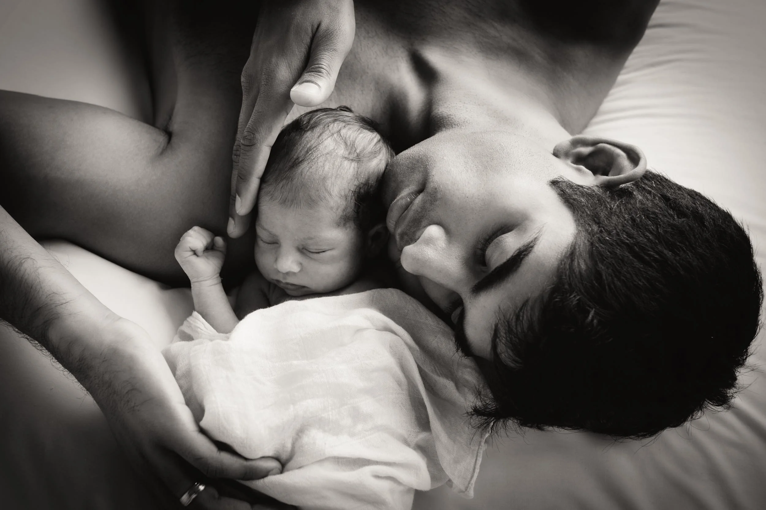 father stroking his newborn son's head