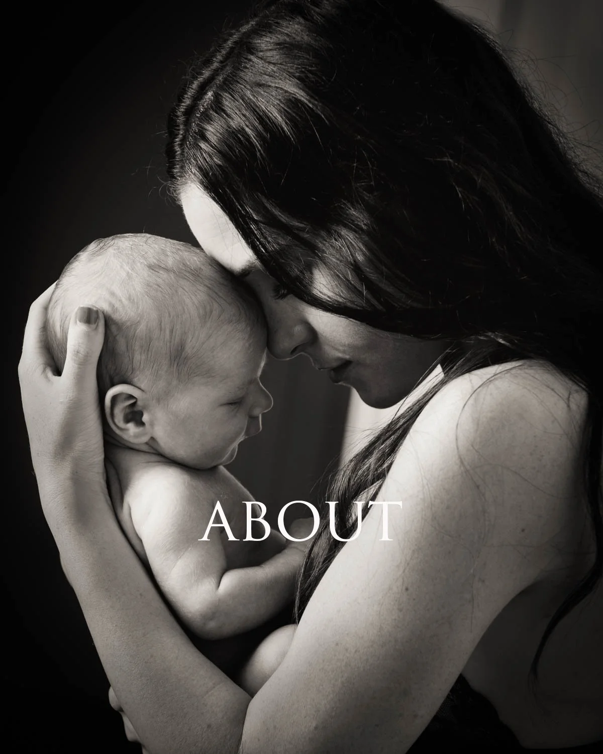 A black-and-white photo of a woman holding a newborn baby close, with their foreheads touching, conveying a tender moment.