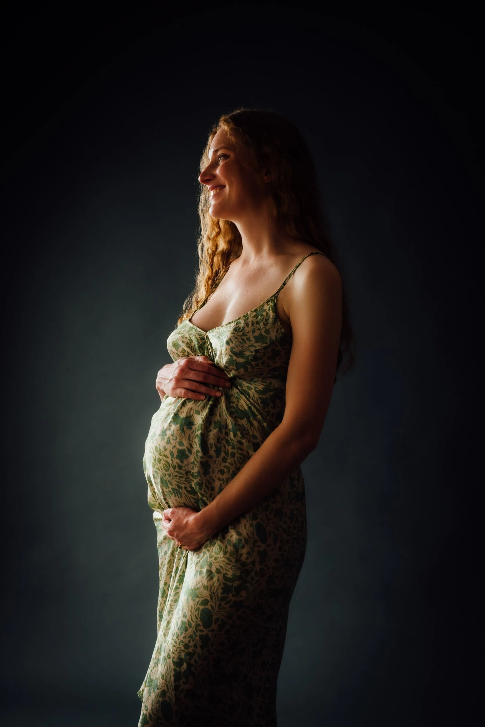 laughing pregnant woman wearing green dress