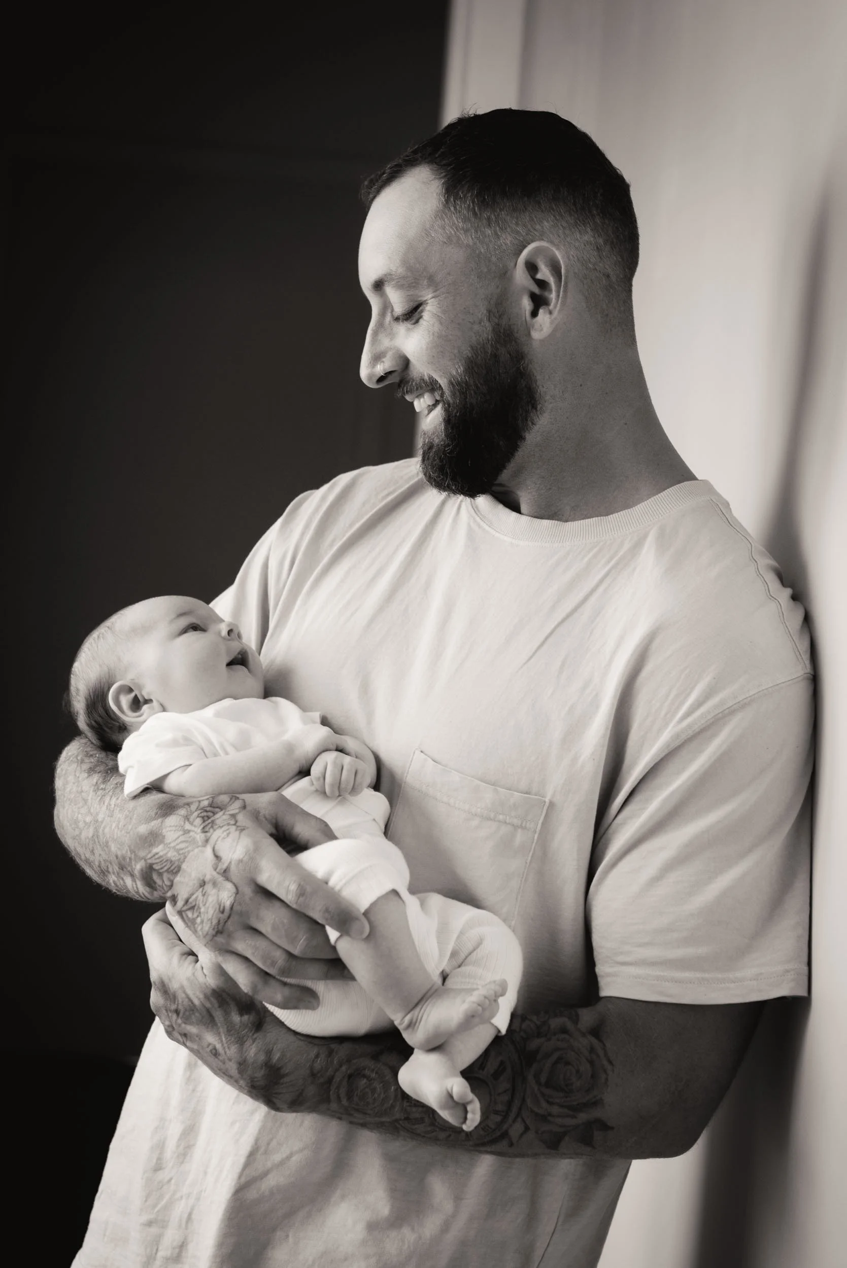 father holding his 4 month old son and smiling