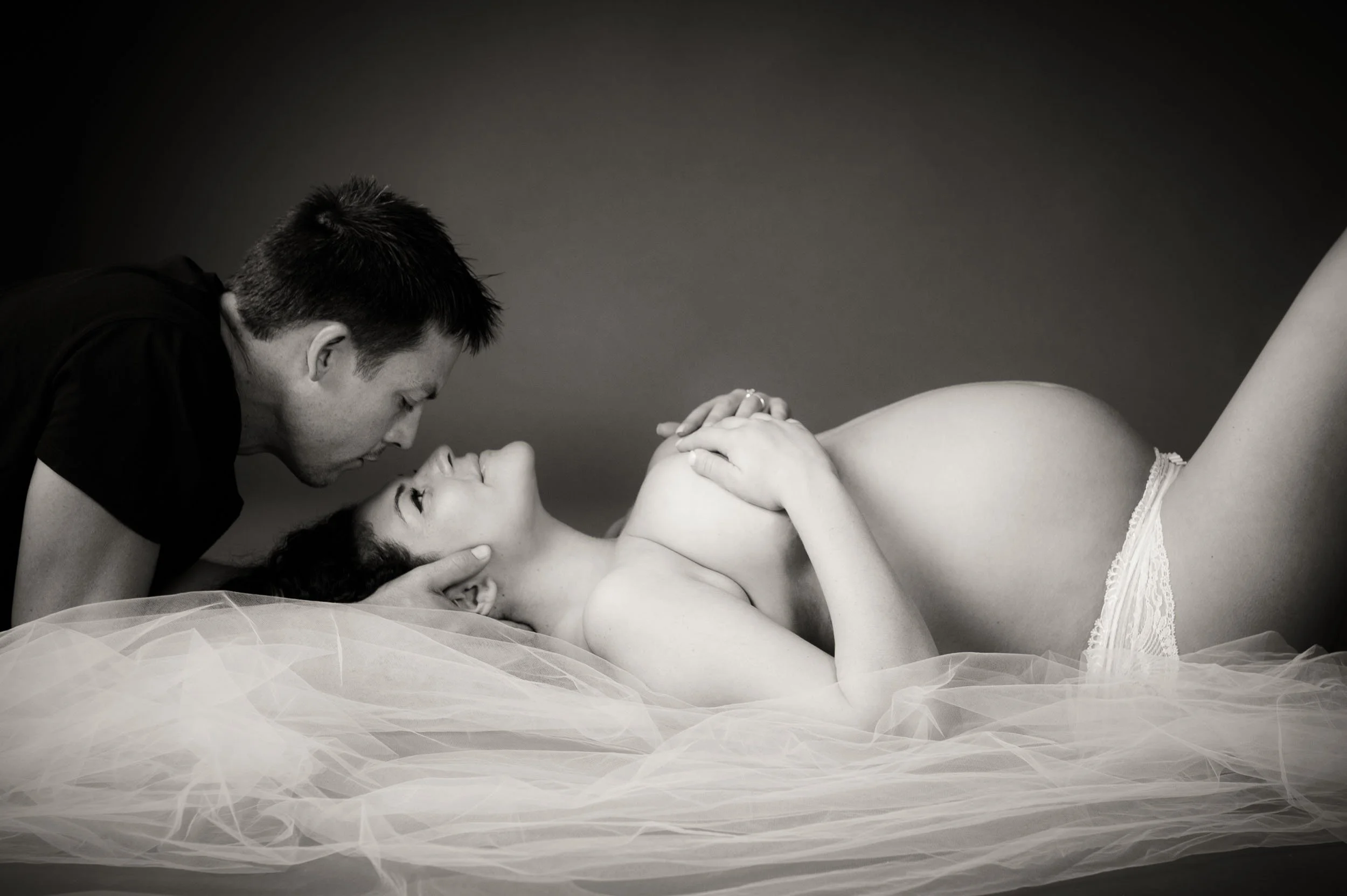 Couple surrounded by tulle veil for a Maternity Photography Photoshoot 