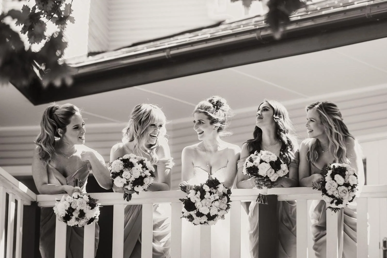 Candid wedding photo of Bride and bridesmaids smiling at home dressed and ready to leave 