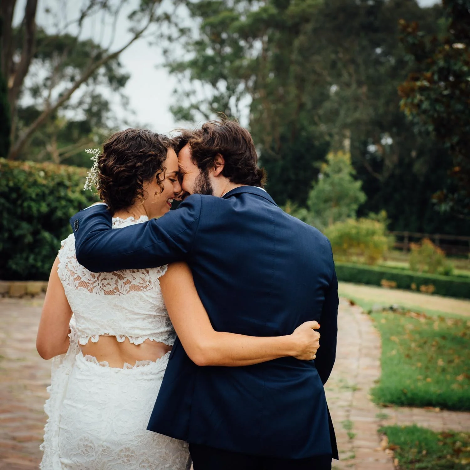 Romantic wedding photo of bride and groom kissing walking away 
