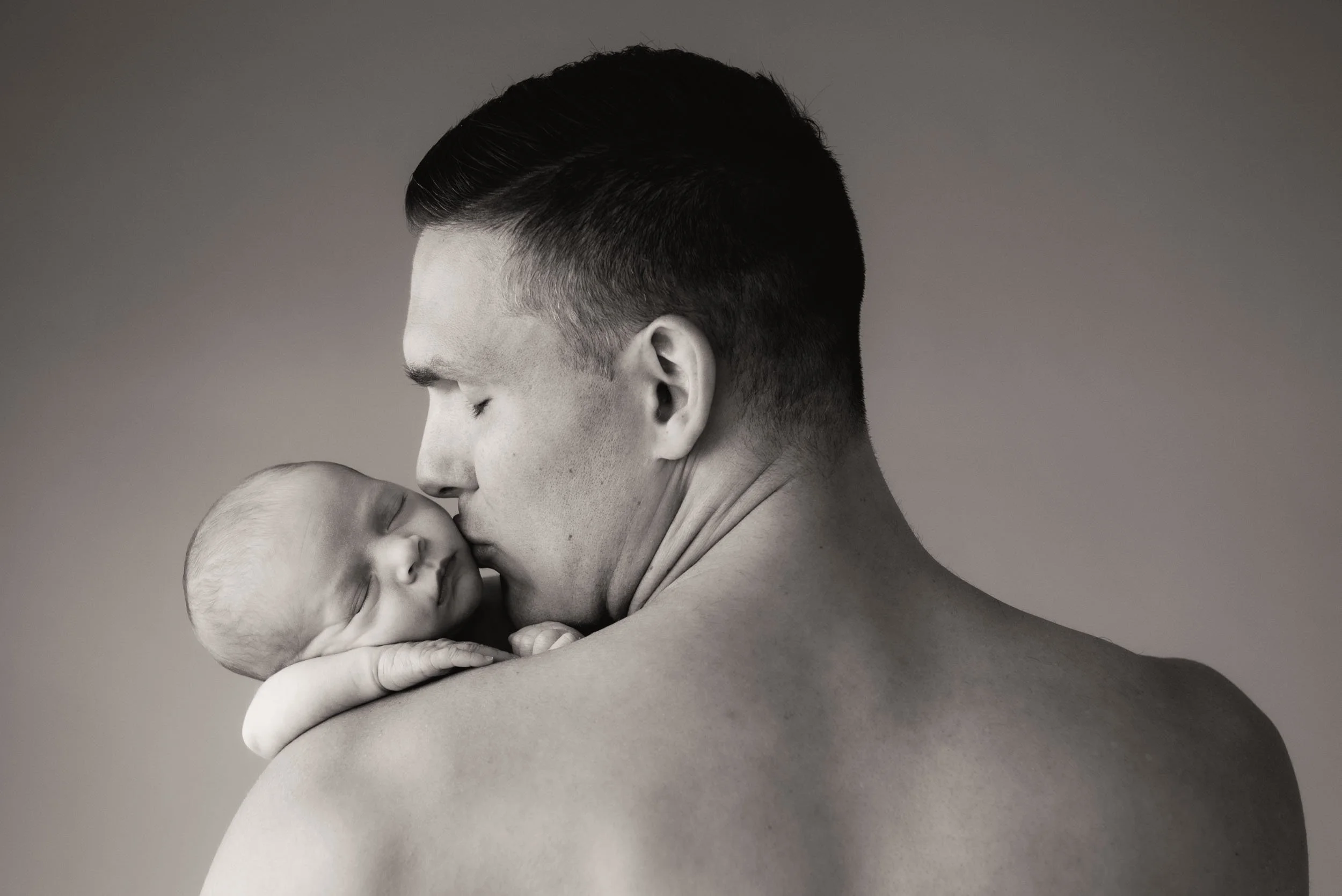 newborn photoshoot sydney of father kissing sleeping child