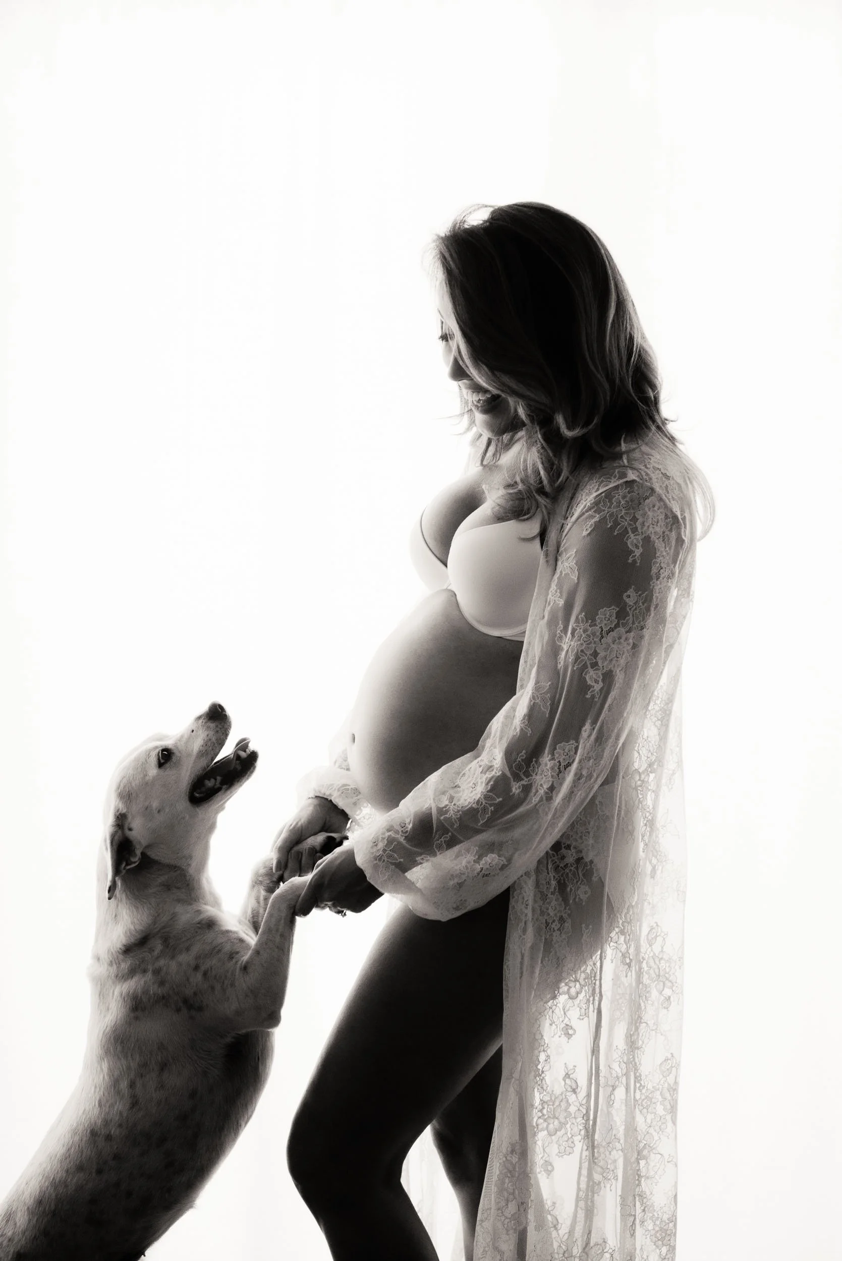 woman playing with her dog in a maternity photography session