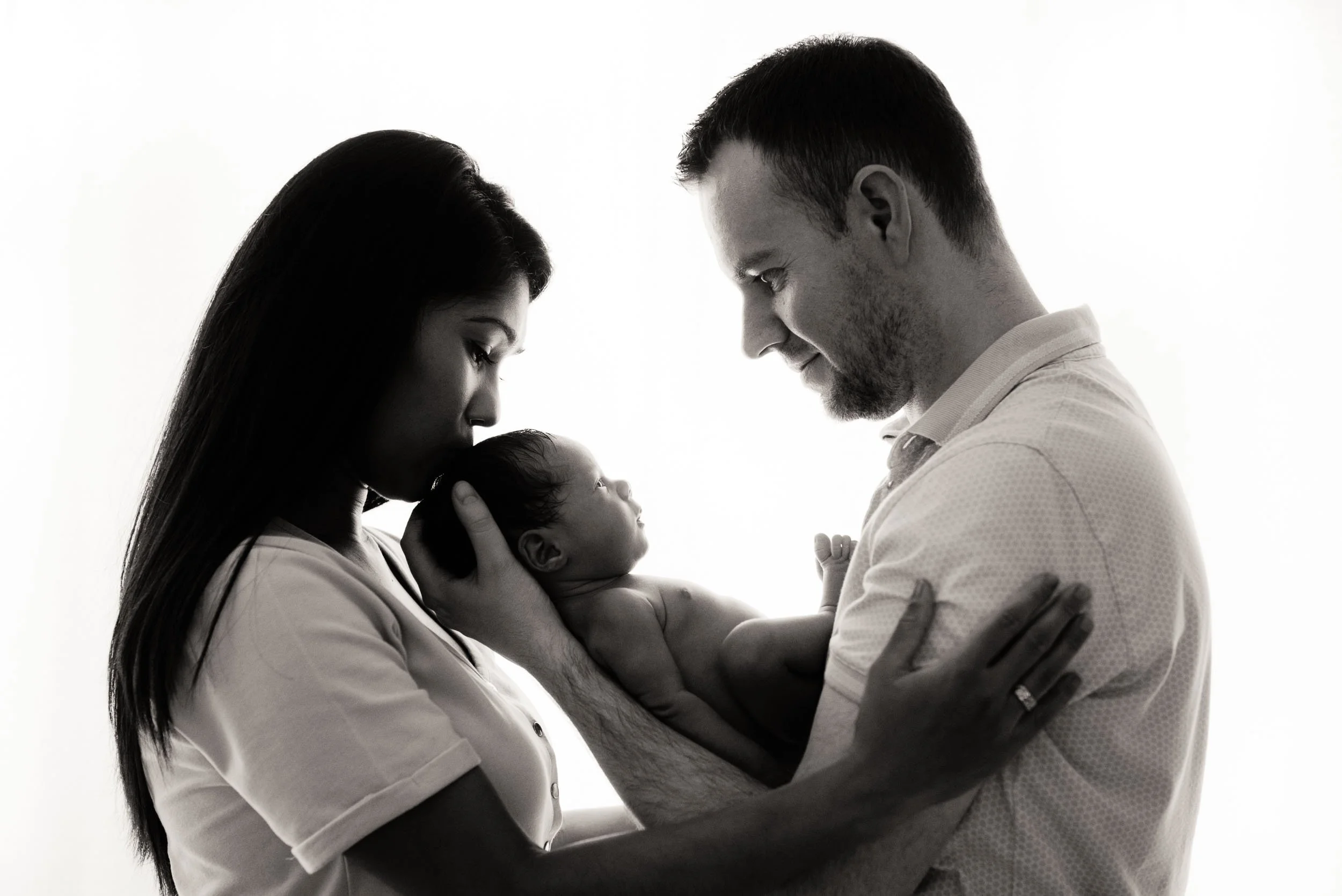 family newborn photoshoot of parents holding their baby