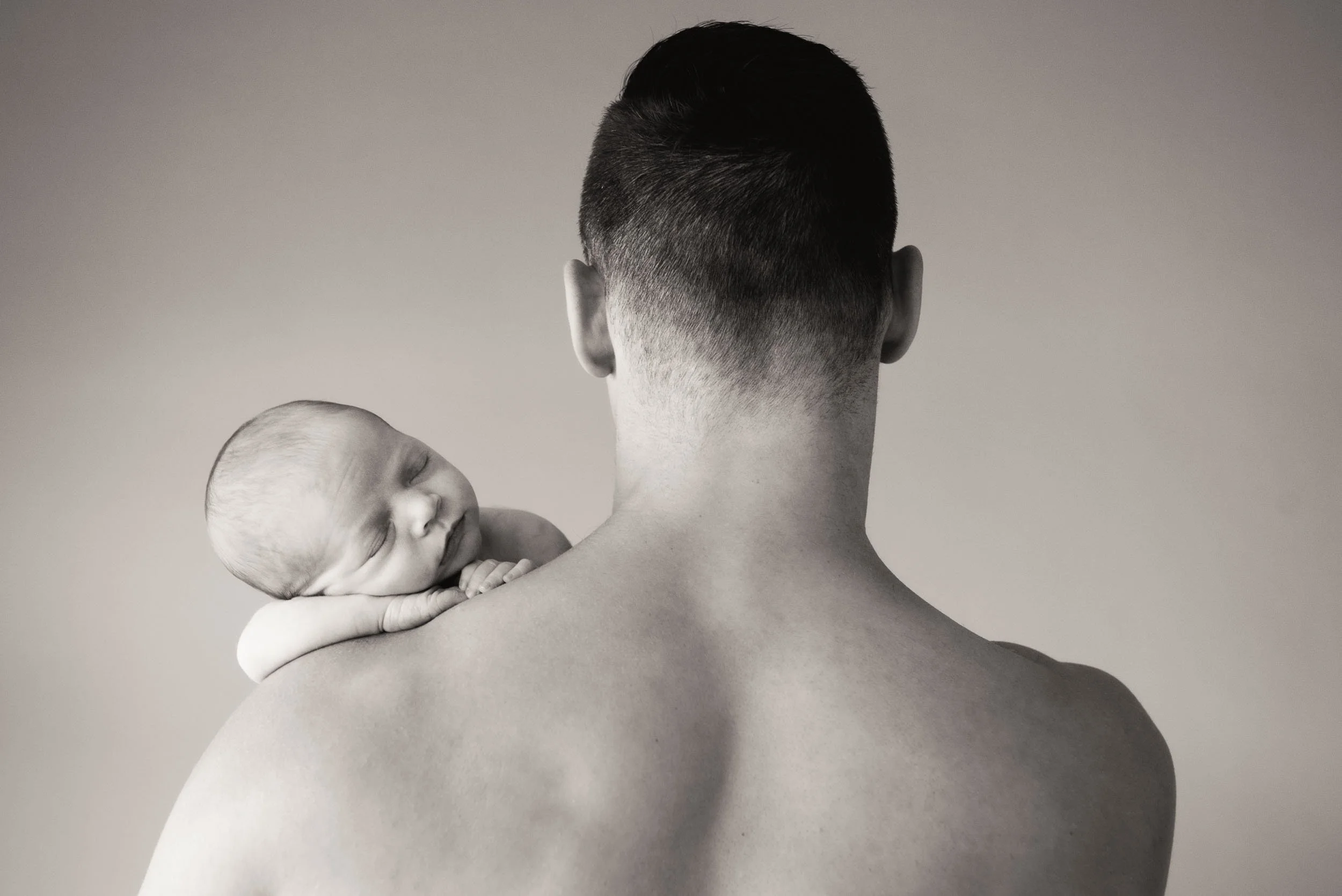 baby sleeping on father's shoulder
