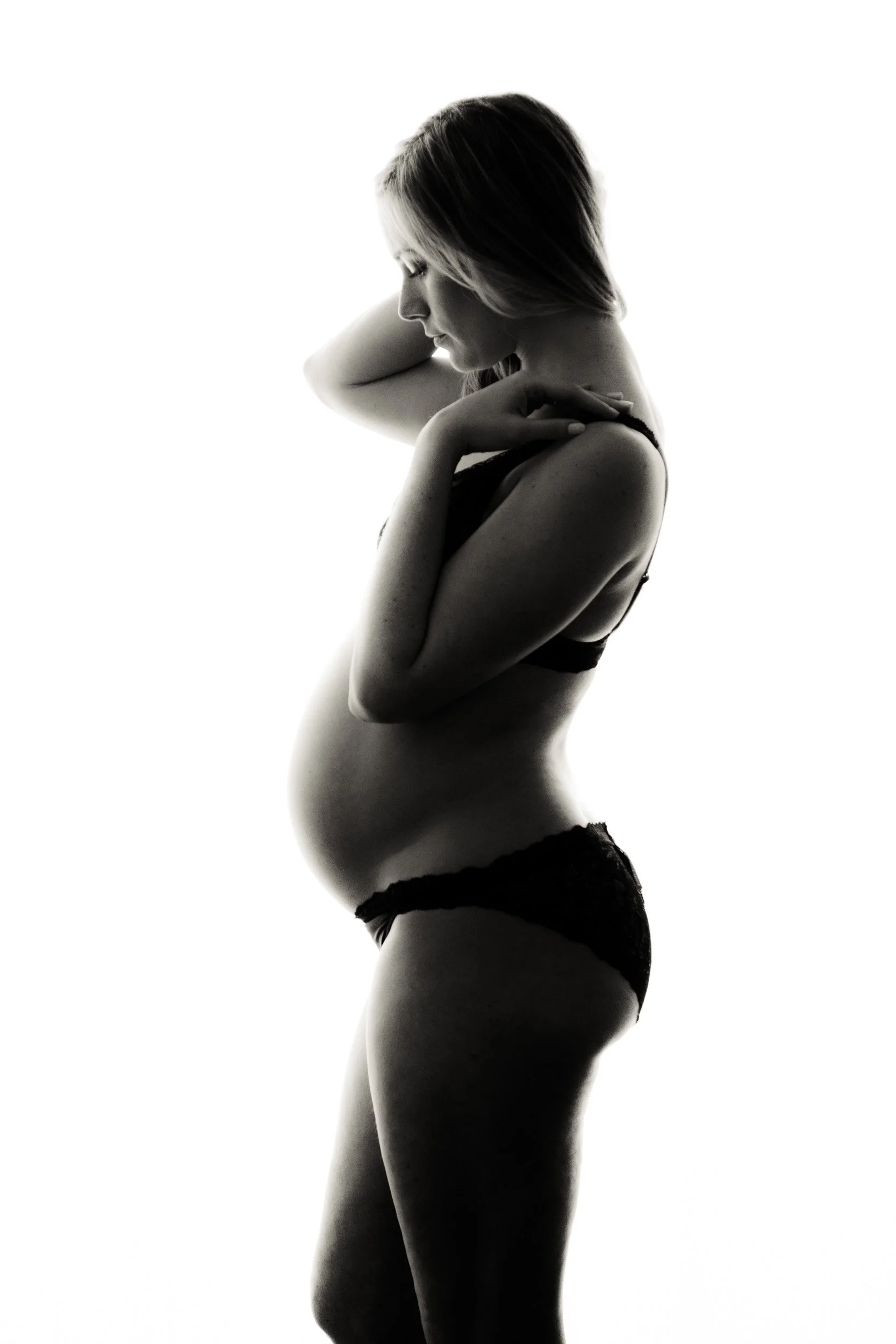 Maternity portrait of a woman in underwear side on