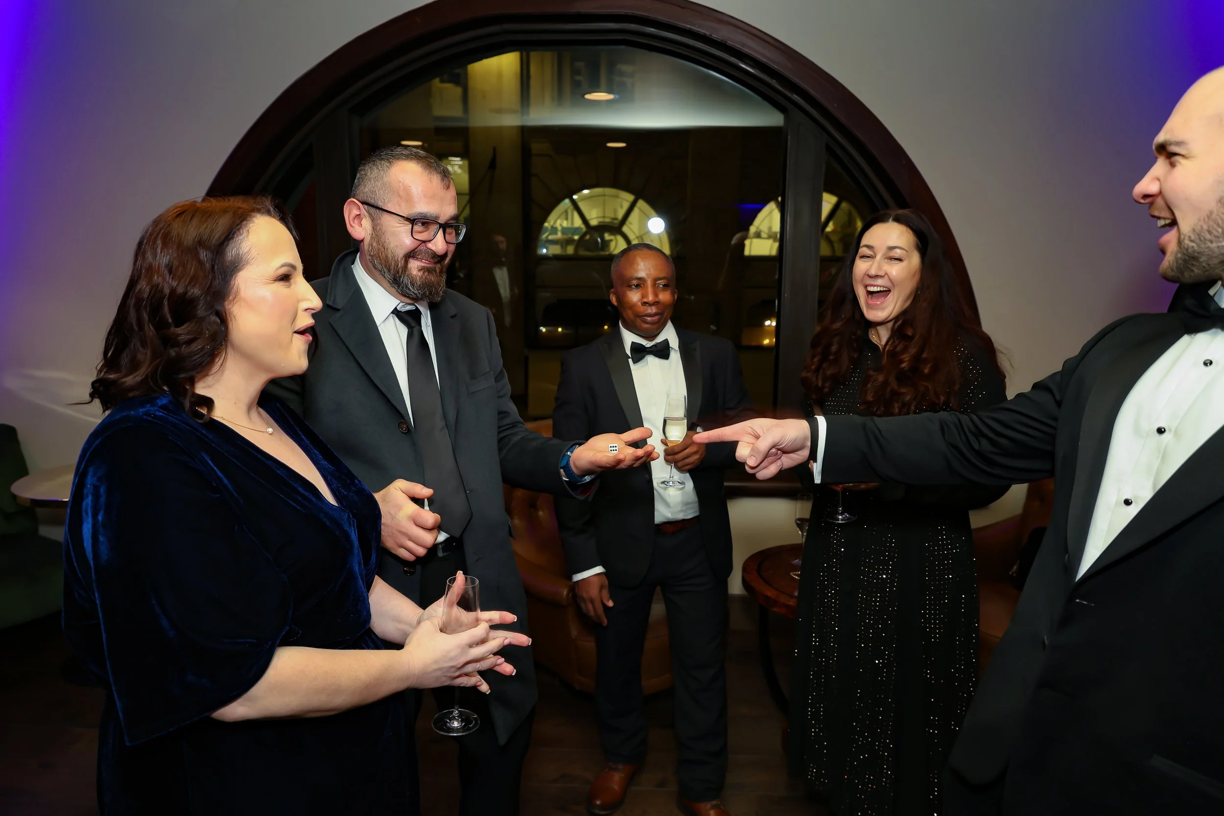 Magician performing a close-up card trick to corporate associates at a business event.