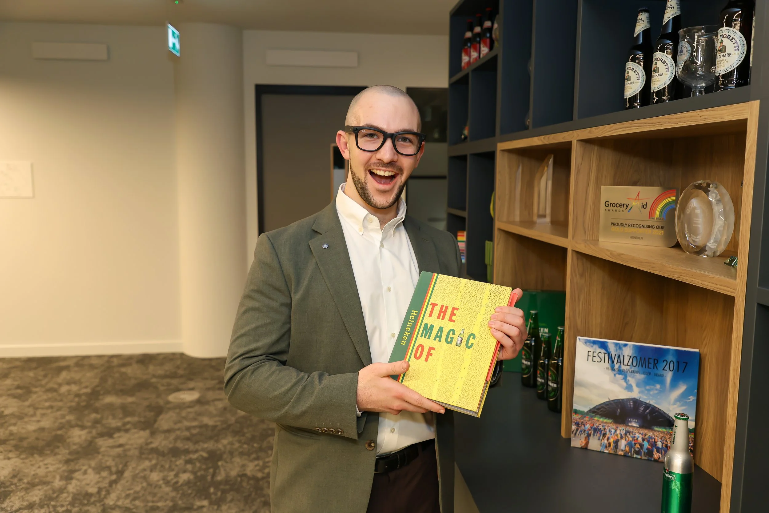 London magician proudly holding a company brand book during a corporate event at reception.