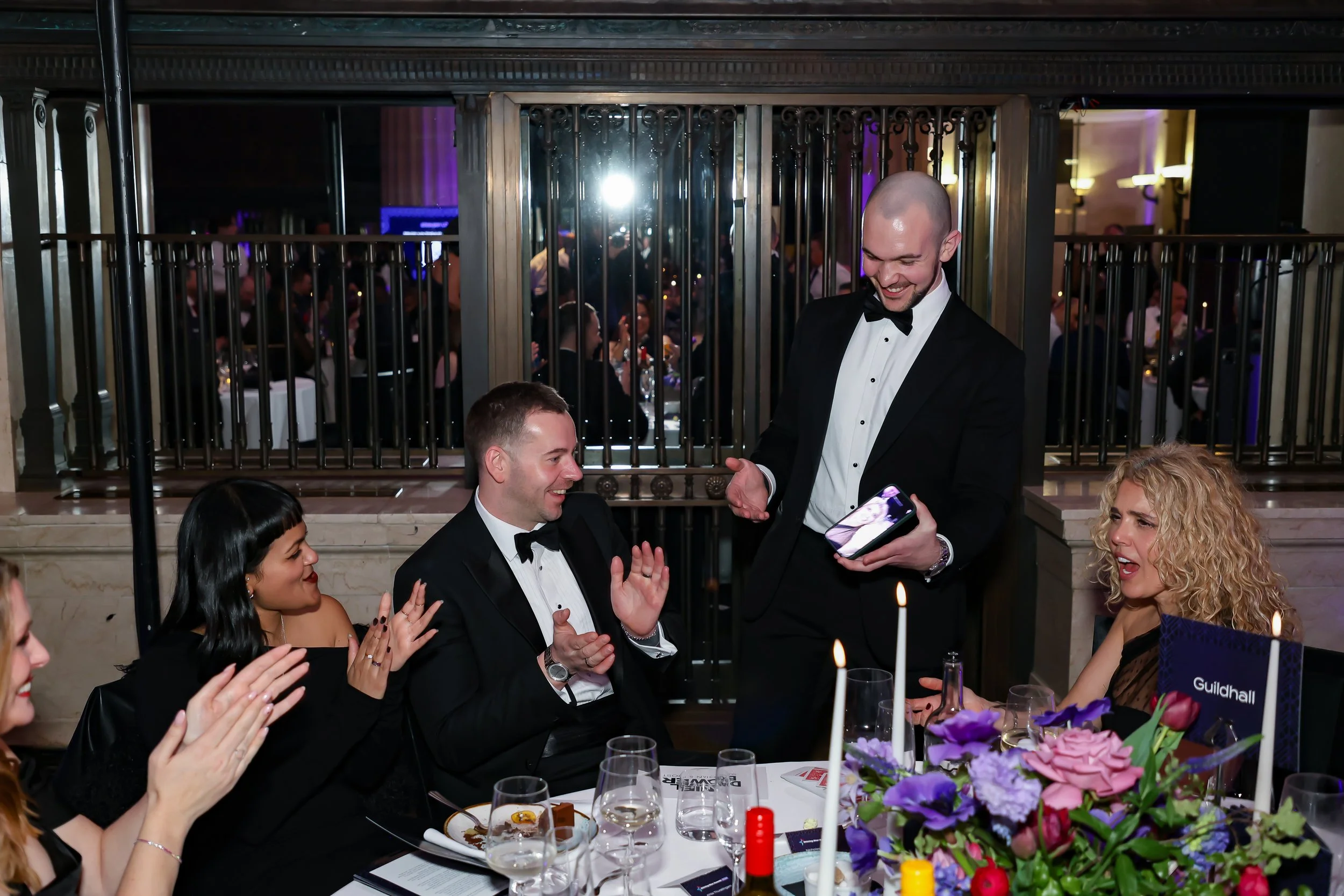 A professional magician delivering table magic during a formal corporate dinner.