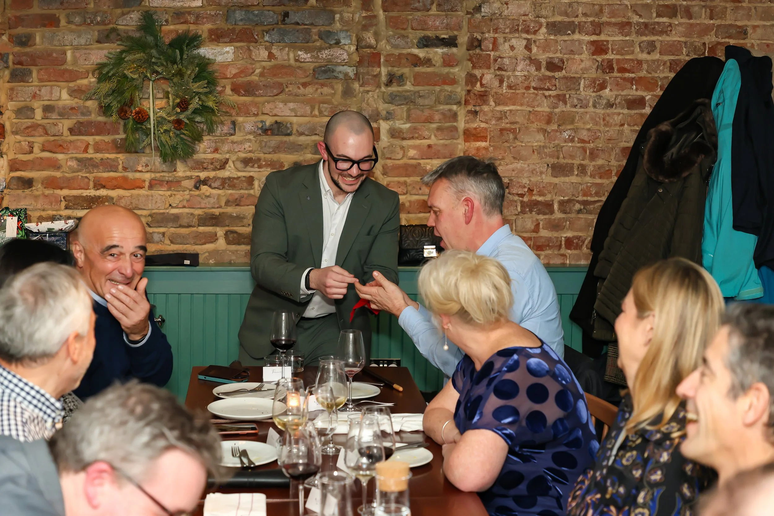 Magician involving corporate guests in interactive magic during a formal dinner event.