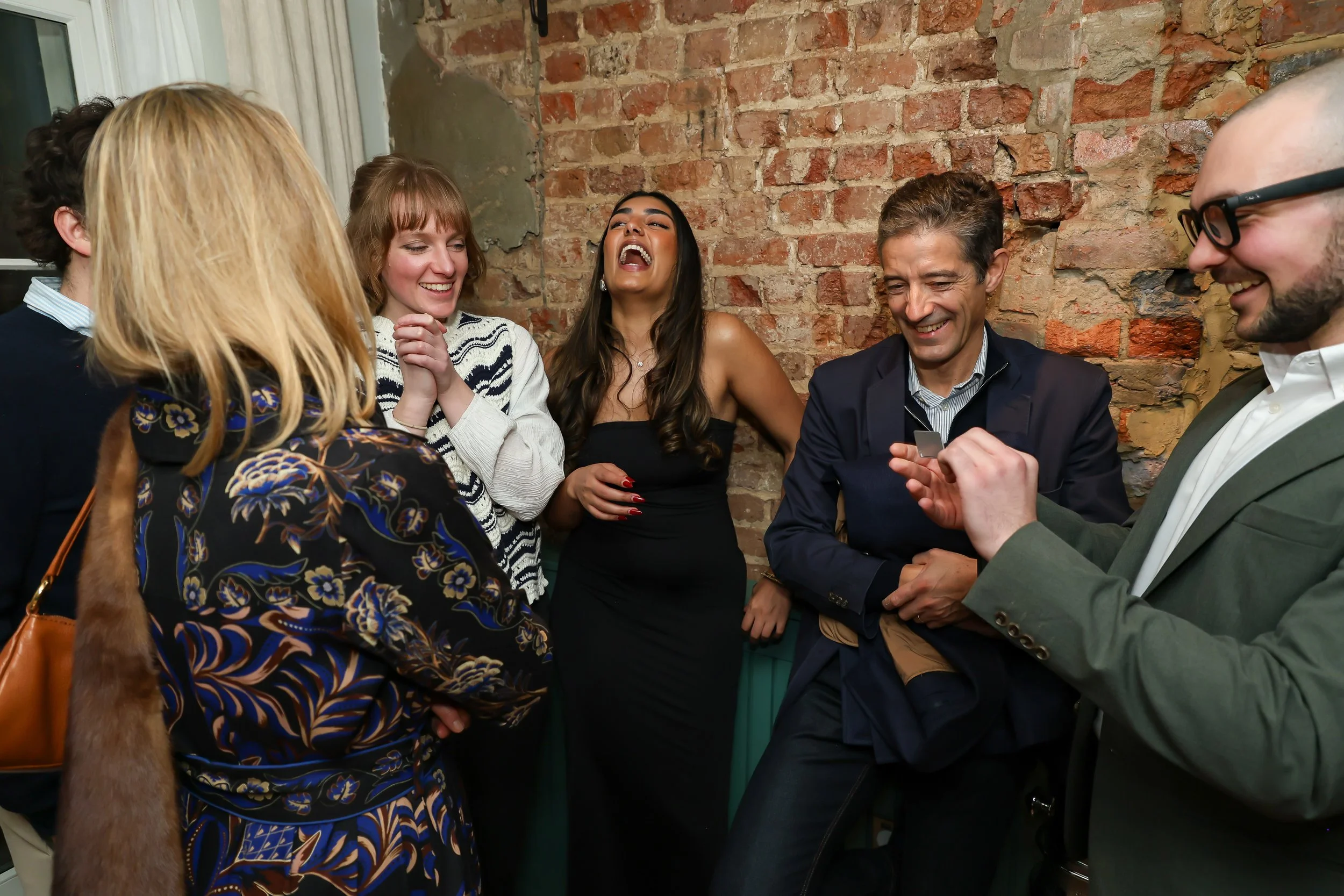 Corporate guests enjoying and applauding live entertainment at the reception.