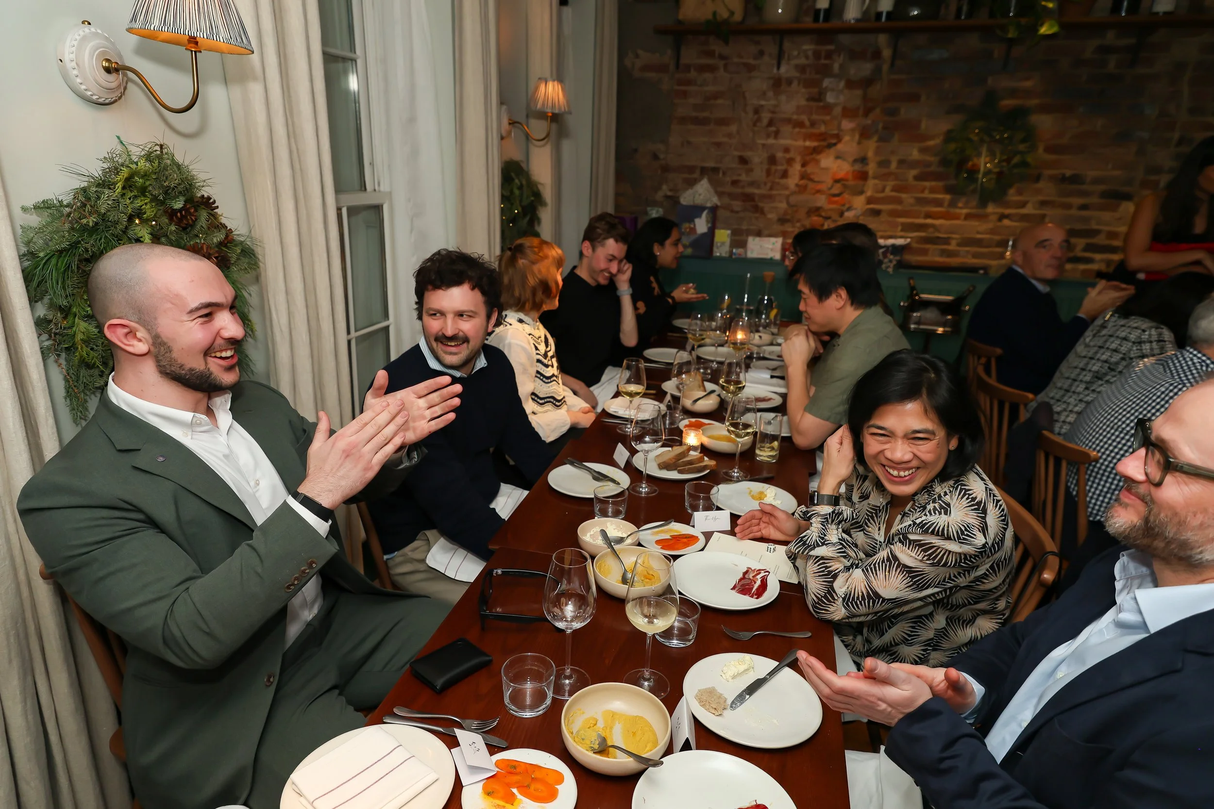 Guests taking part in live close-up magic while dining at a corporate event.