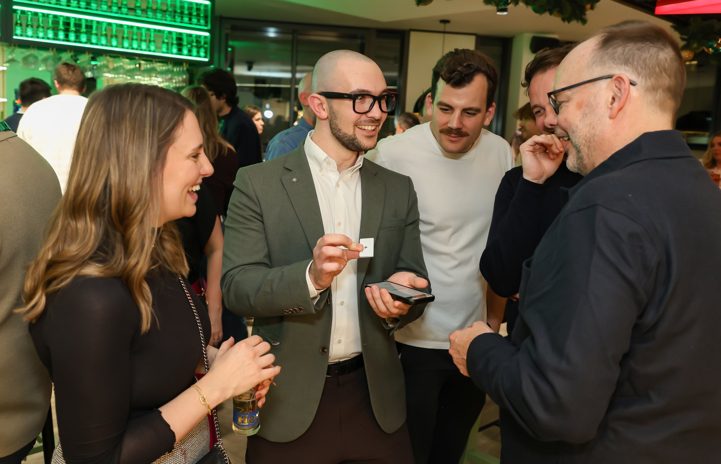 Close-up walk-around magic featuring a cellphone trick at a corporate reception.