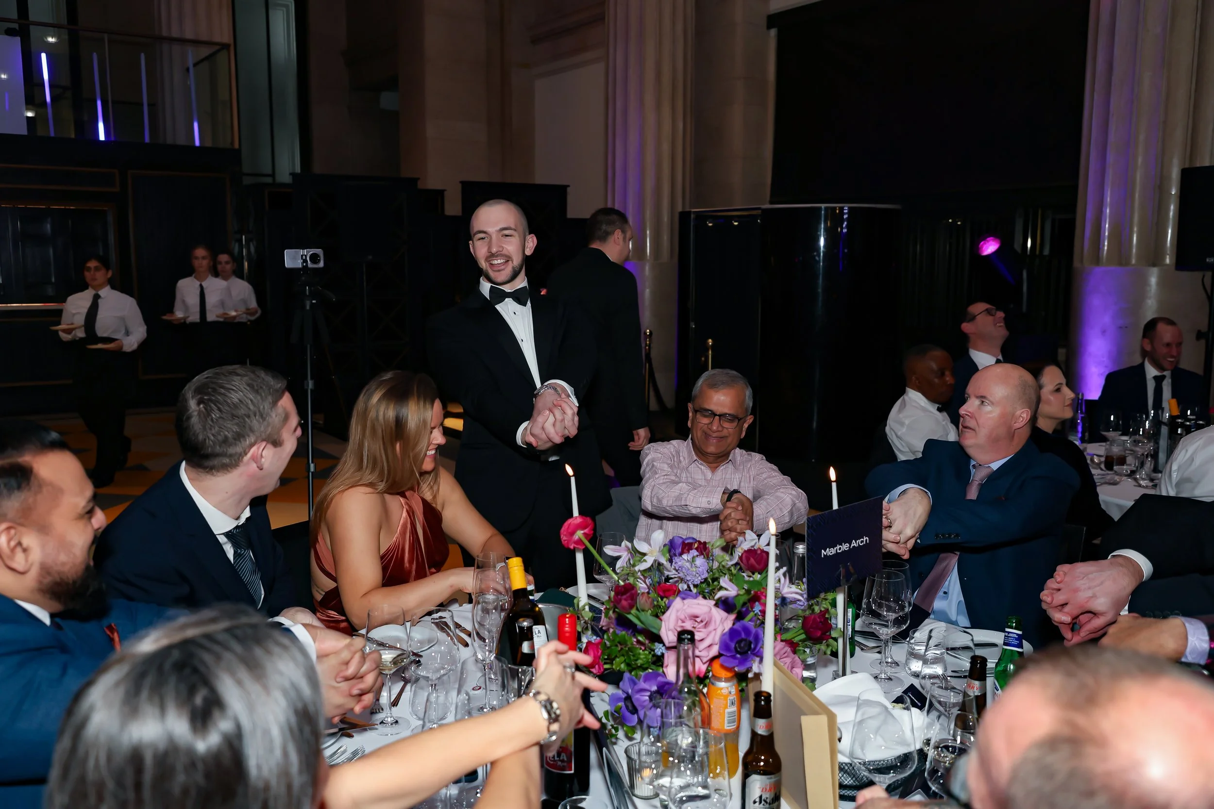Corporate dinner guests taking part in an interactive table-side magic trick.