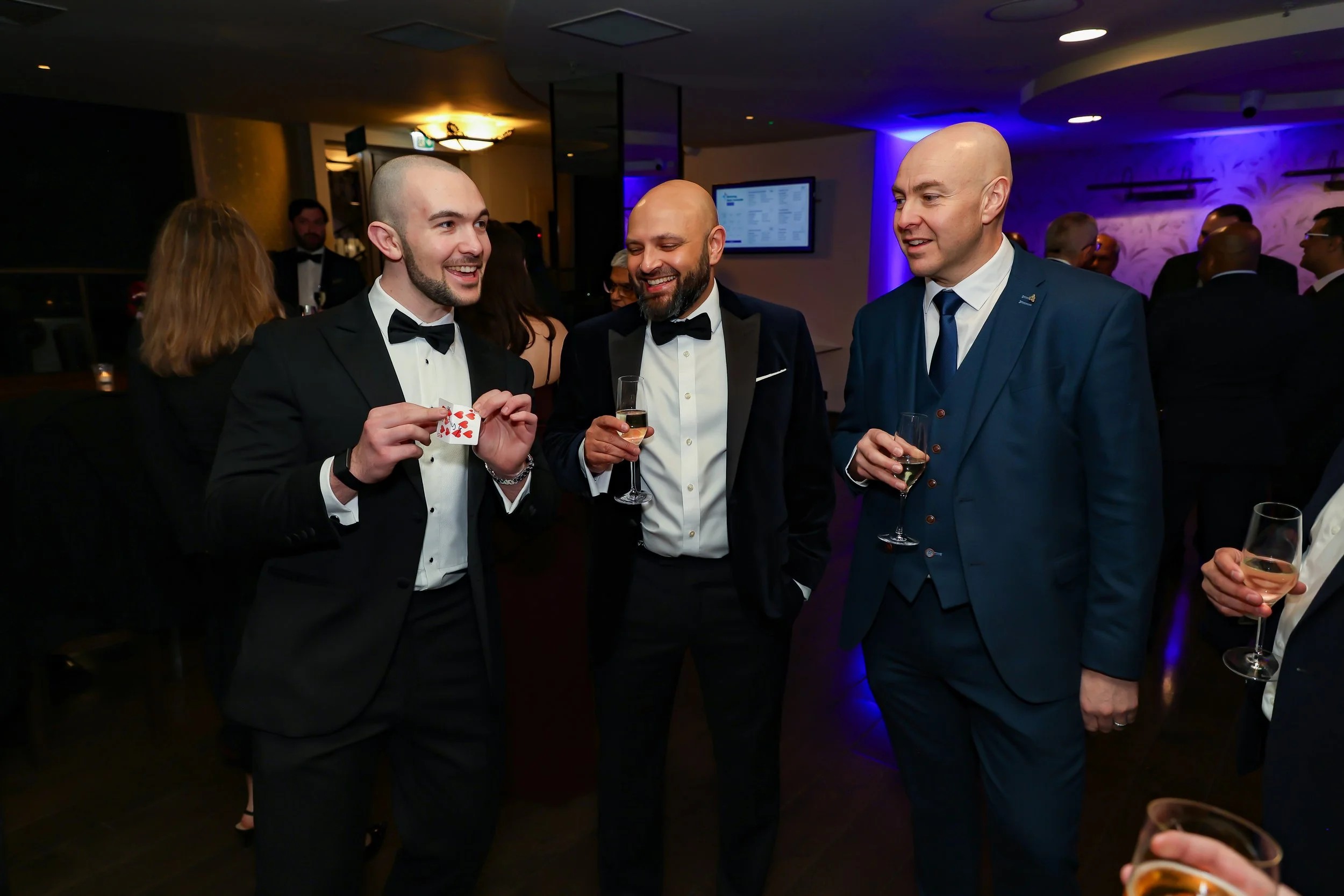 Magician with his card trick to the corporate senior associates. 