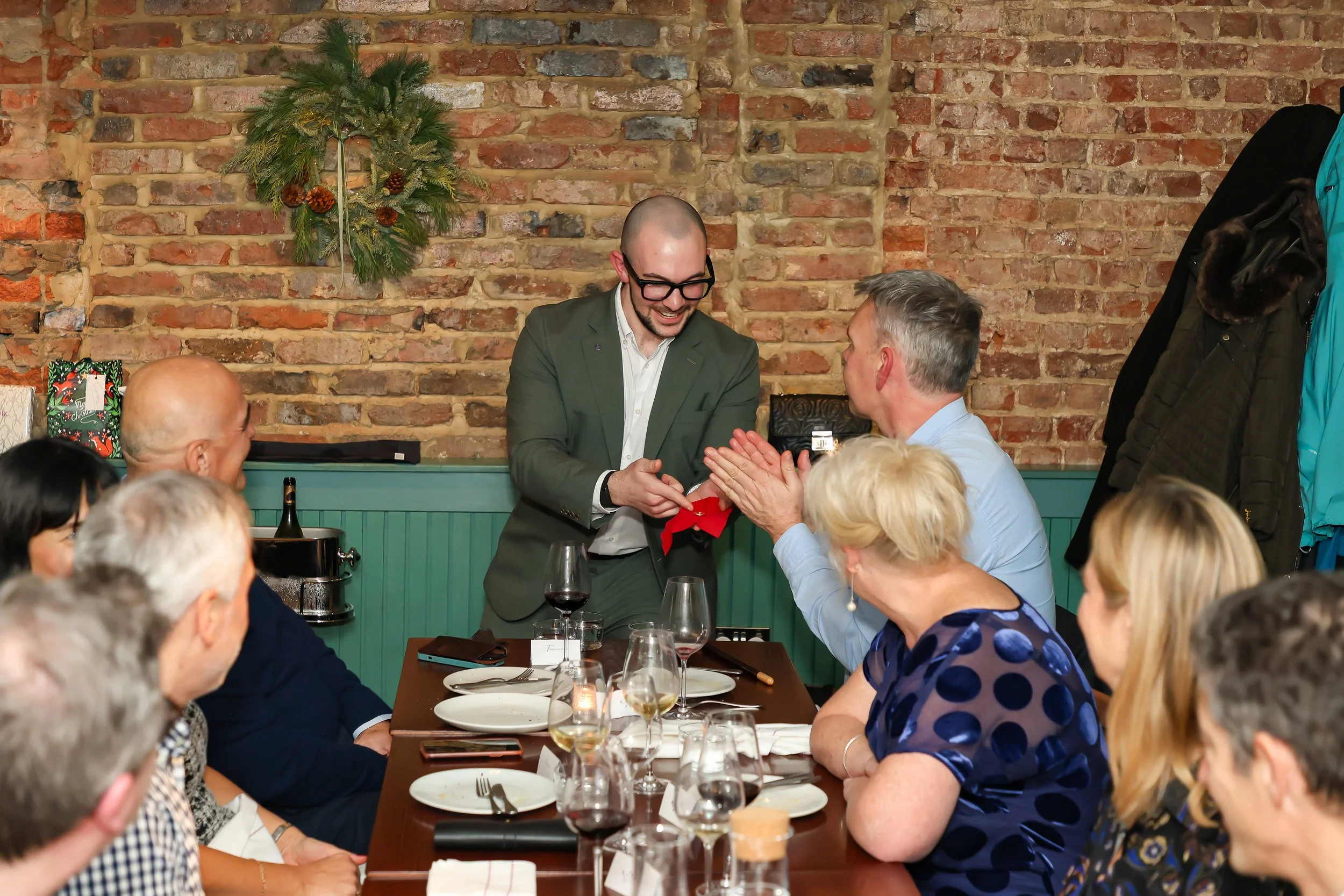 Magician involving corporate guests in interactive magic during a formal dinner event.