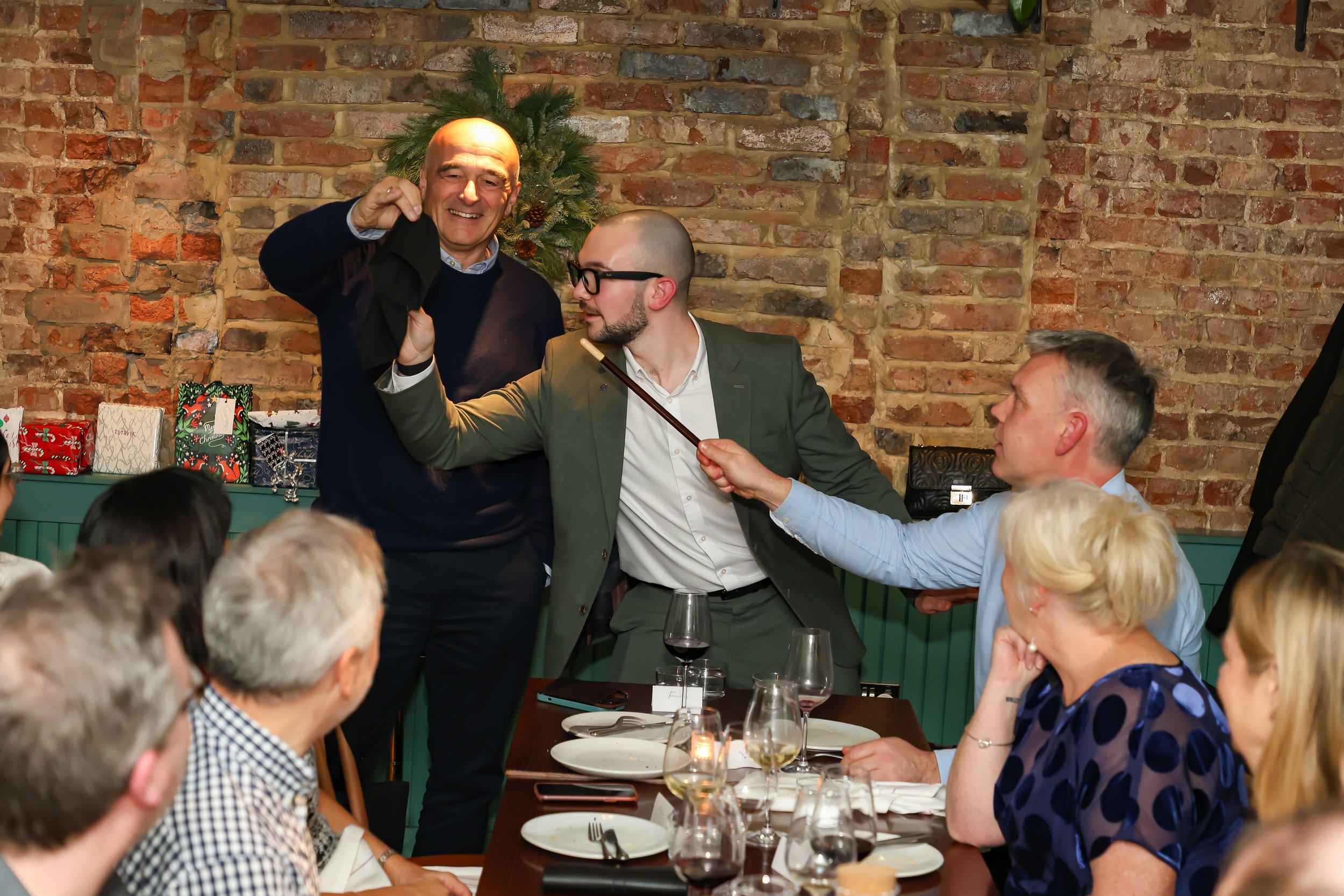 Magician starting a corporate event with guests smiling and engaged at the beginning of the party.