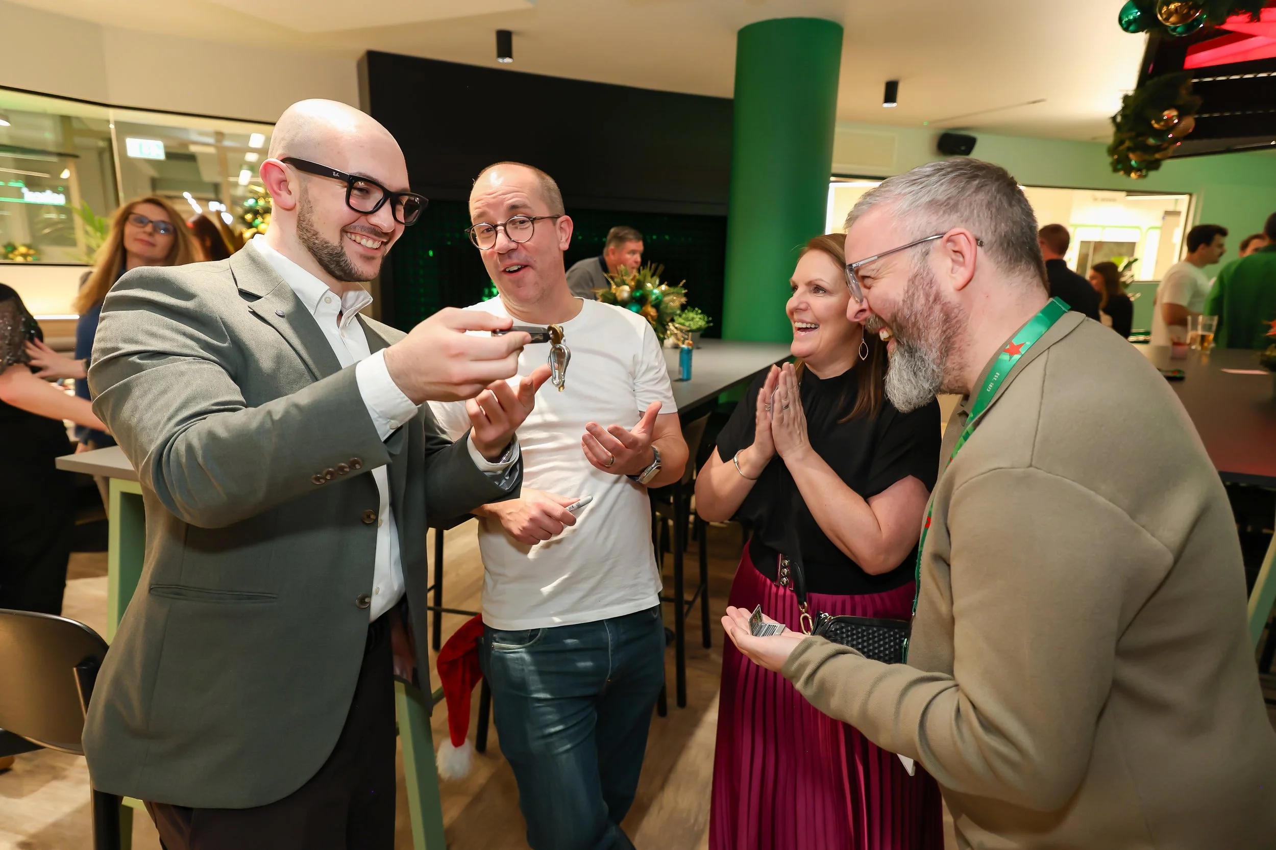 Festive corporate table magic creates laughter and surprise during a Christmas celebration. 