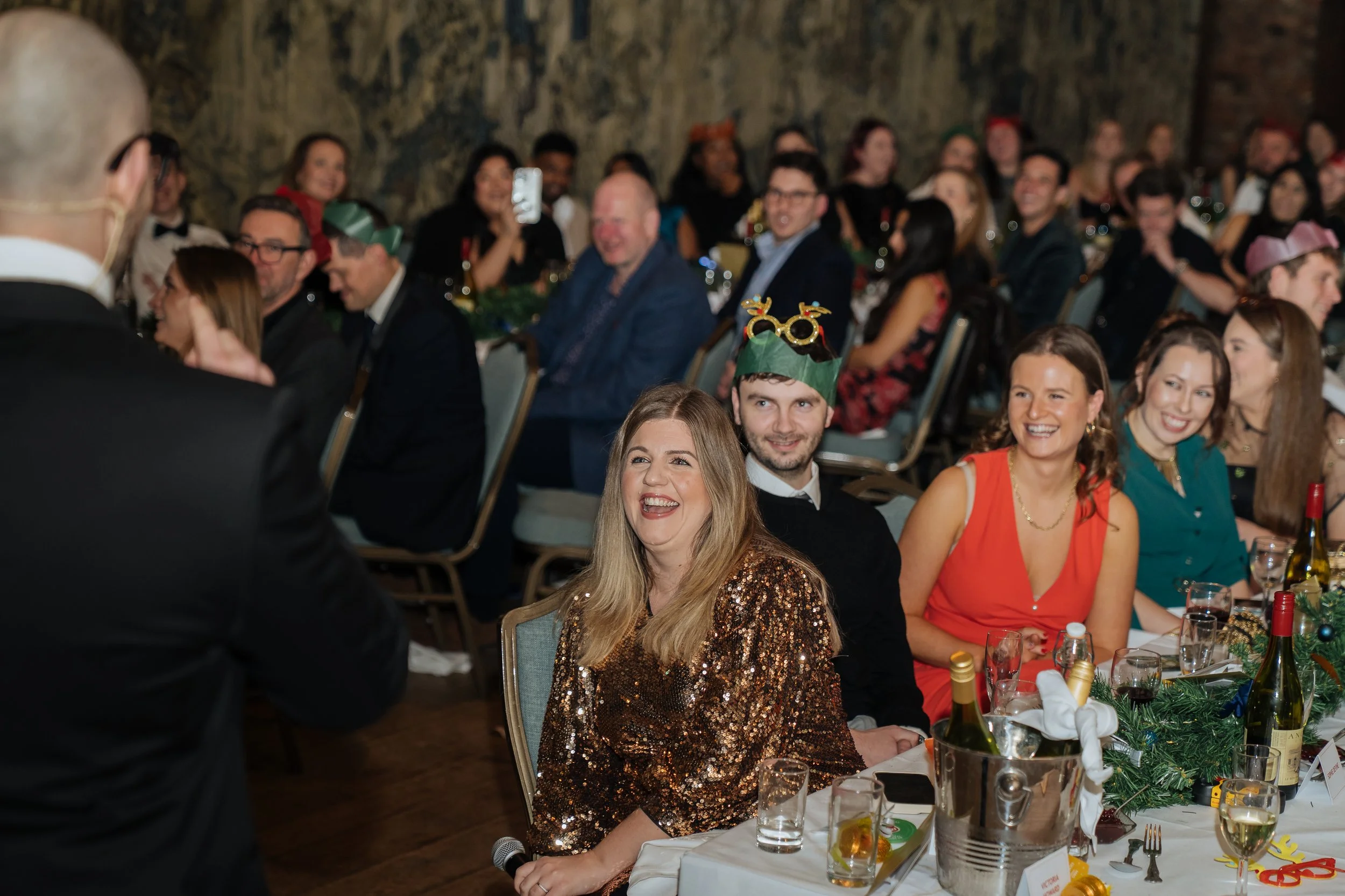 Corporate magician performing table-side magic for guests during a company gala dinner.