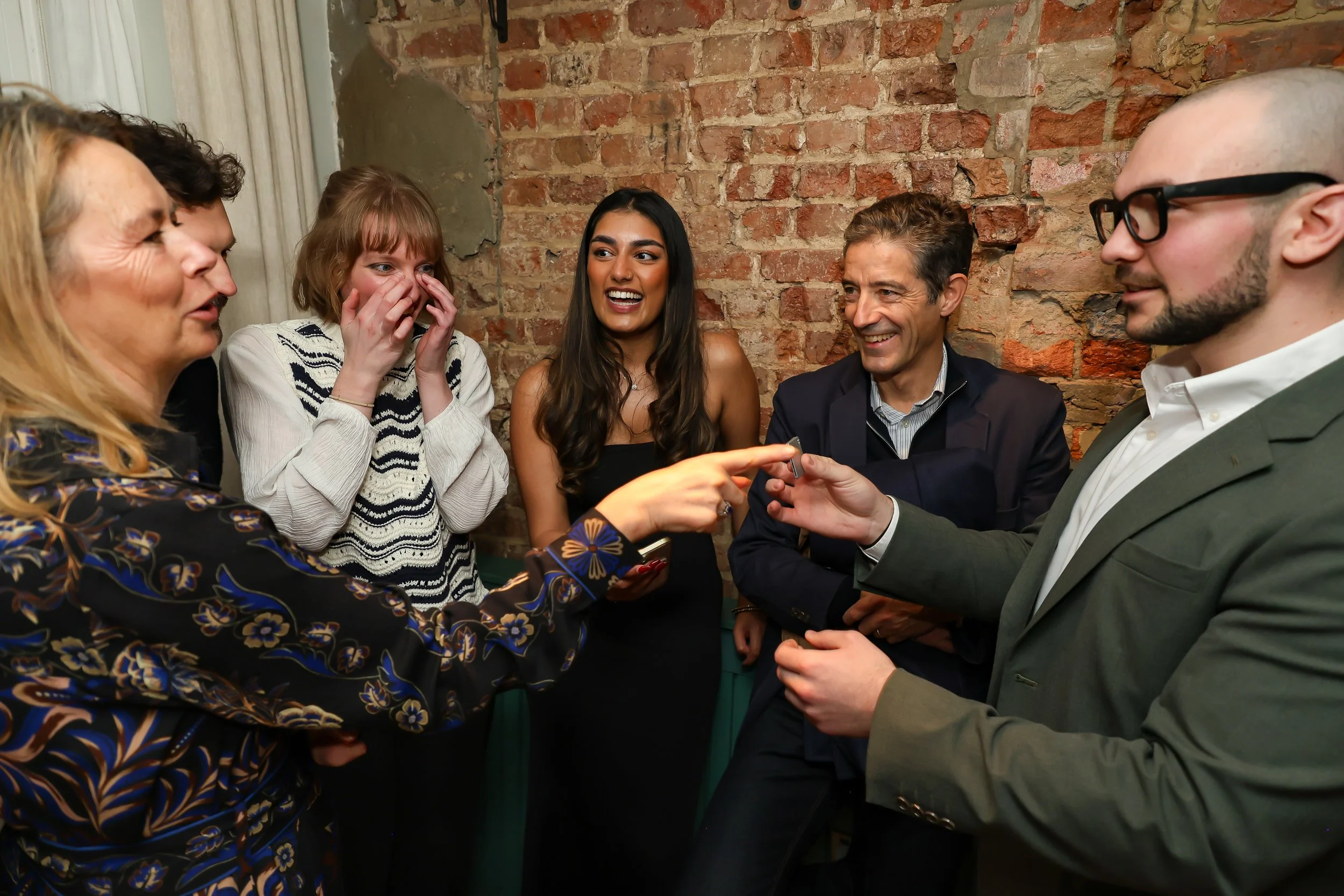 Guests celebrating a successful magic performance during a corporate reception.