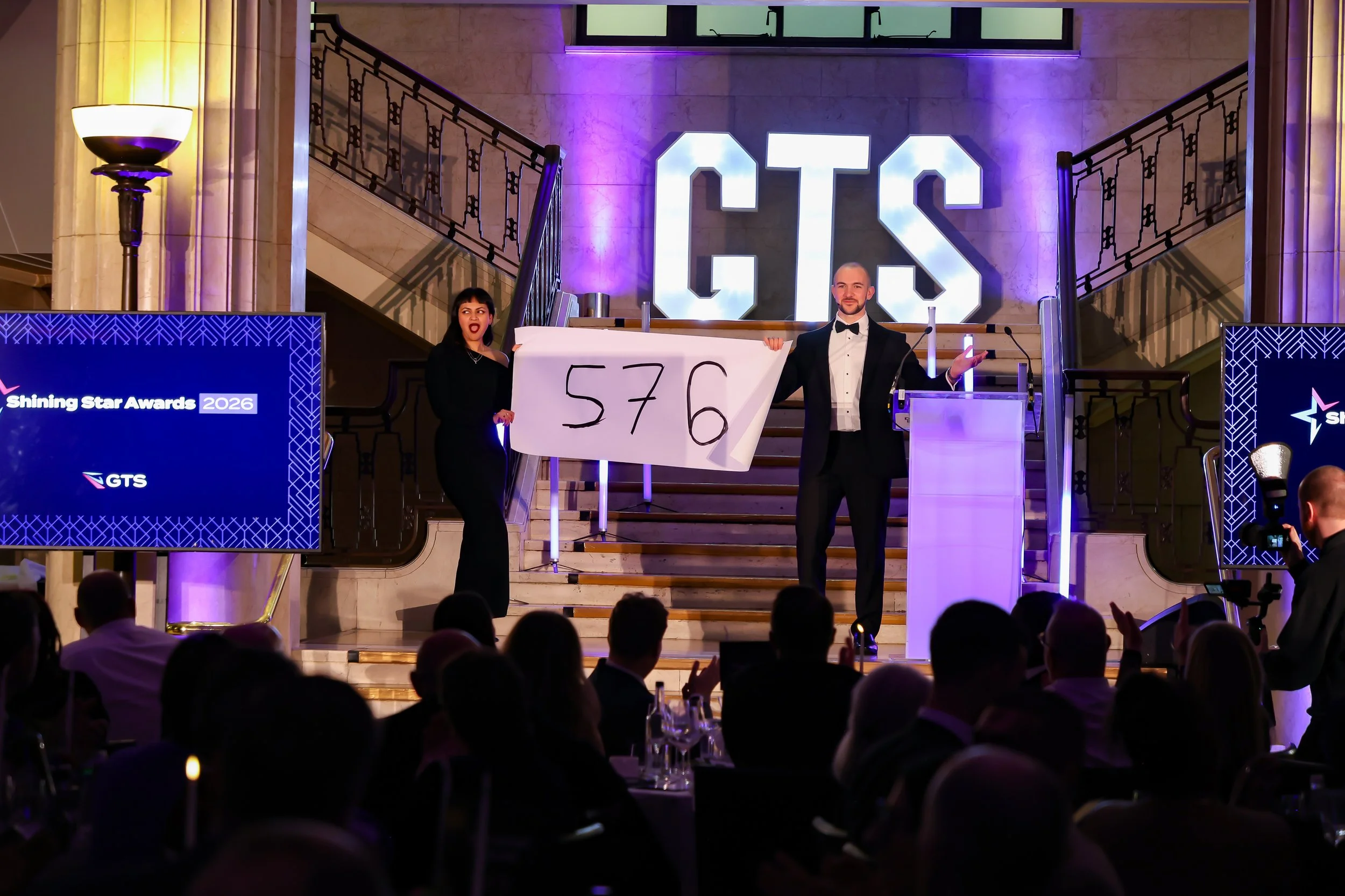 A professional magician involving a guest on stage as the crowd watches in anticipation.