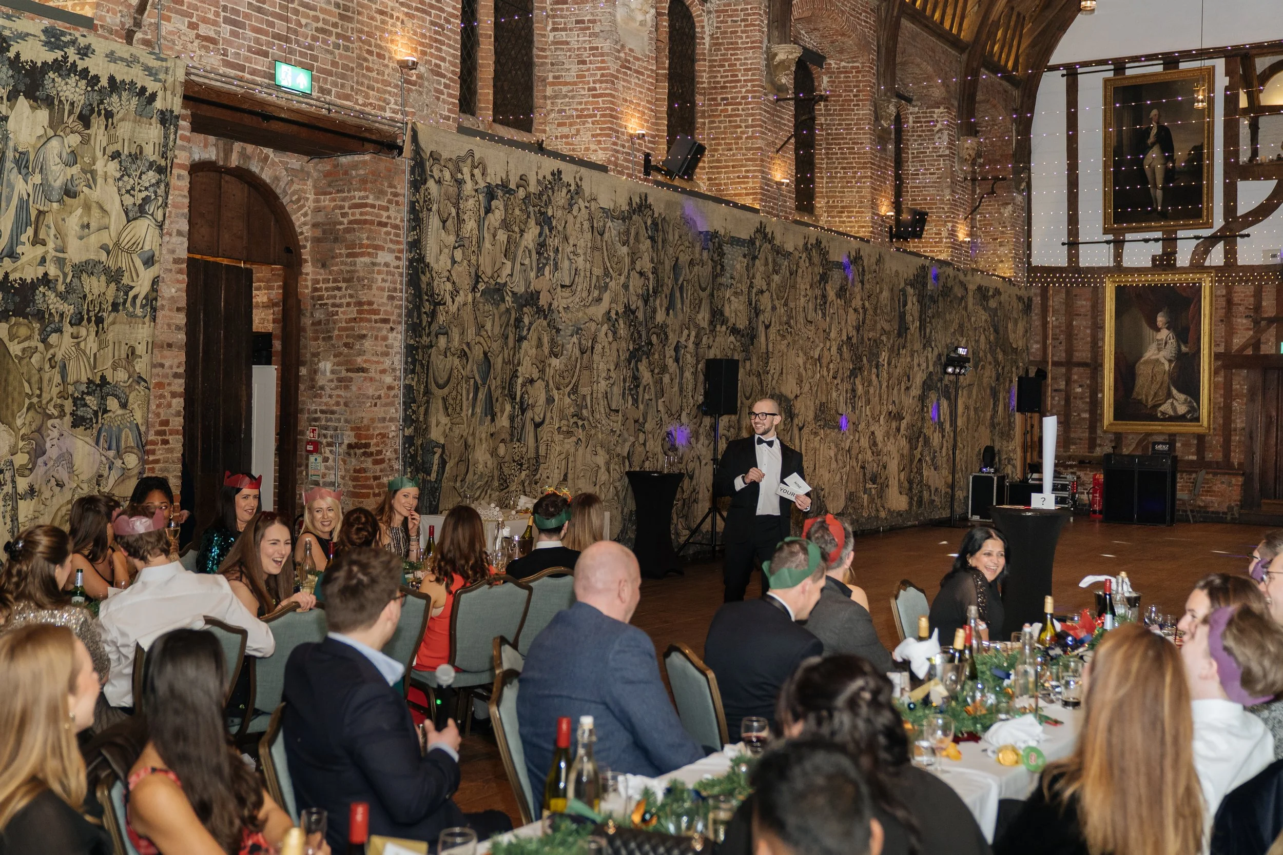 Corporate magician addressing guests with a live performance during a gala dinner.