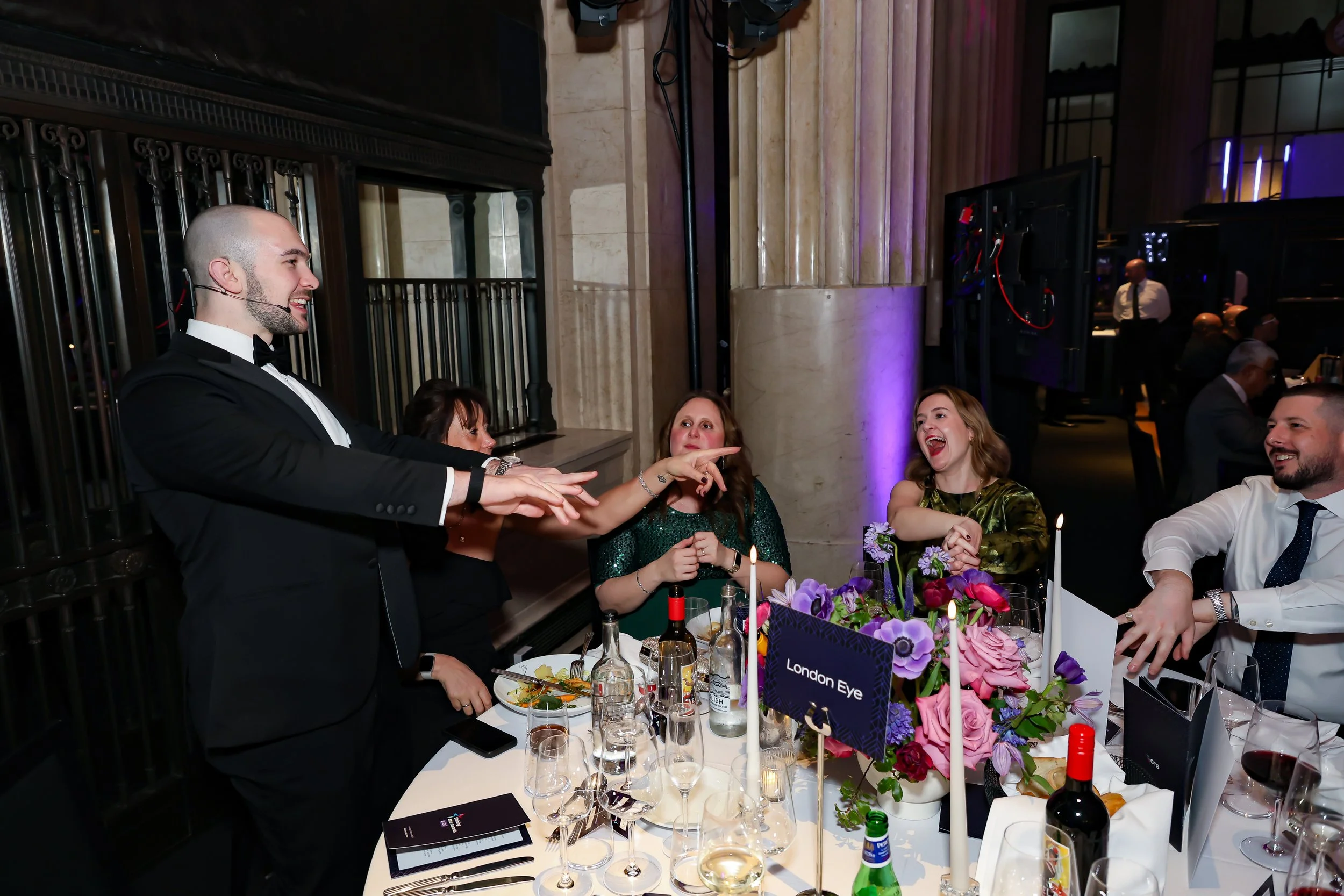 Close-up magic being performed for guests at their table, enhancing the dinner experience.