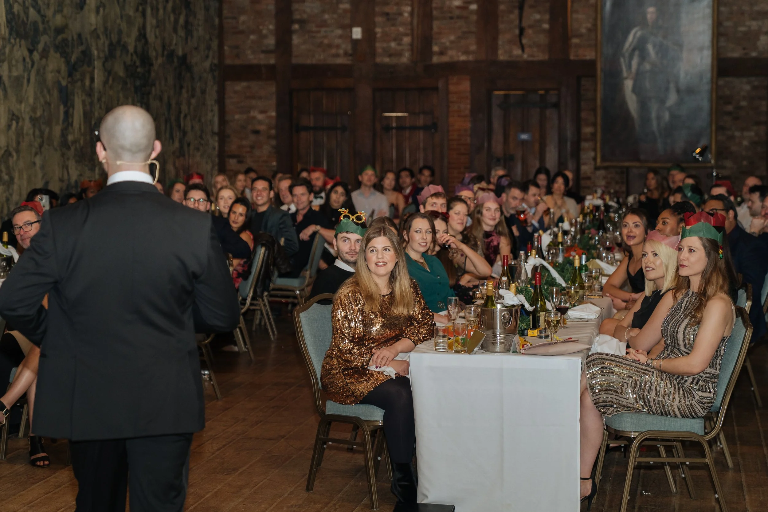 Professional magician engaging a seated corporate audience during a formal dinner.