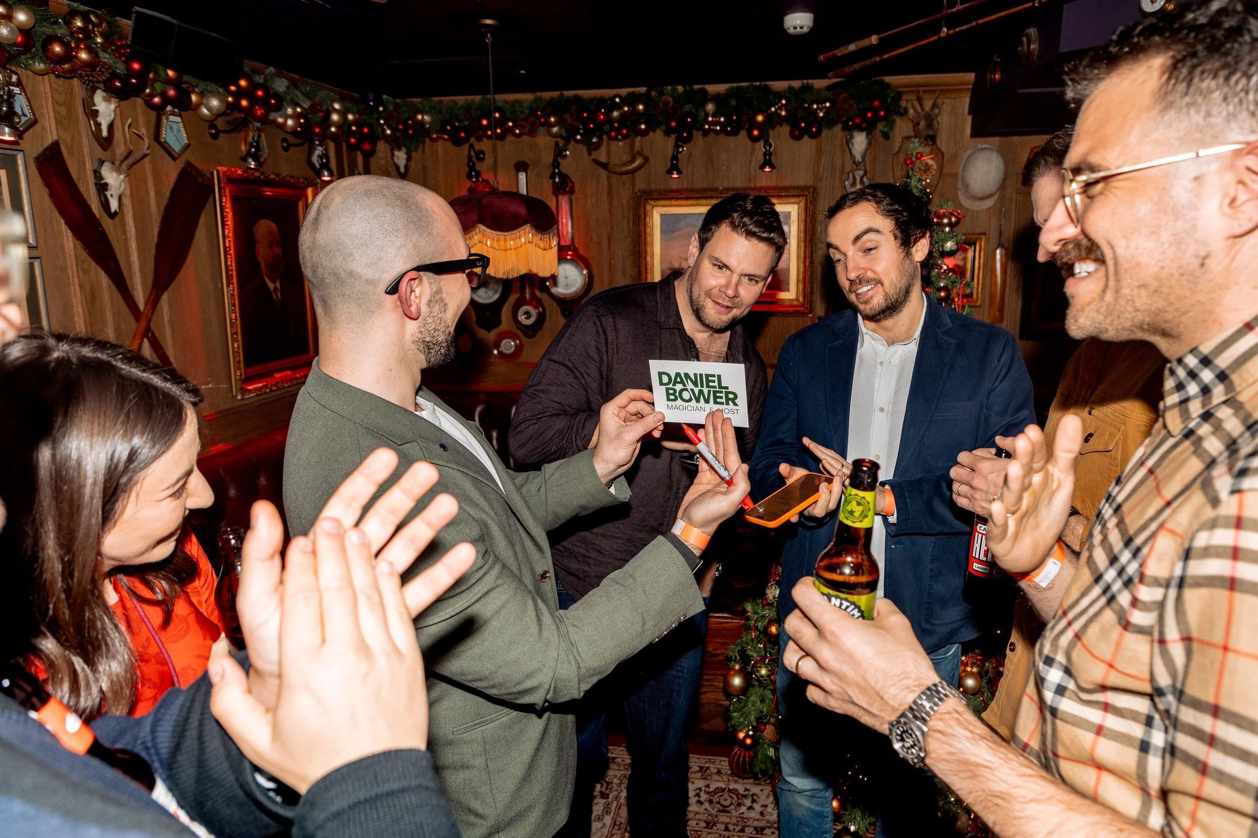 Magician revealing card trick to engaged corporate audience.