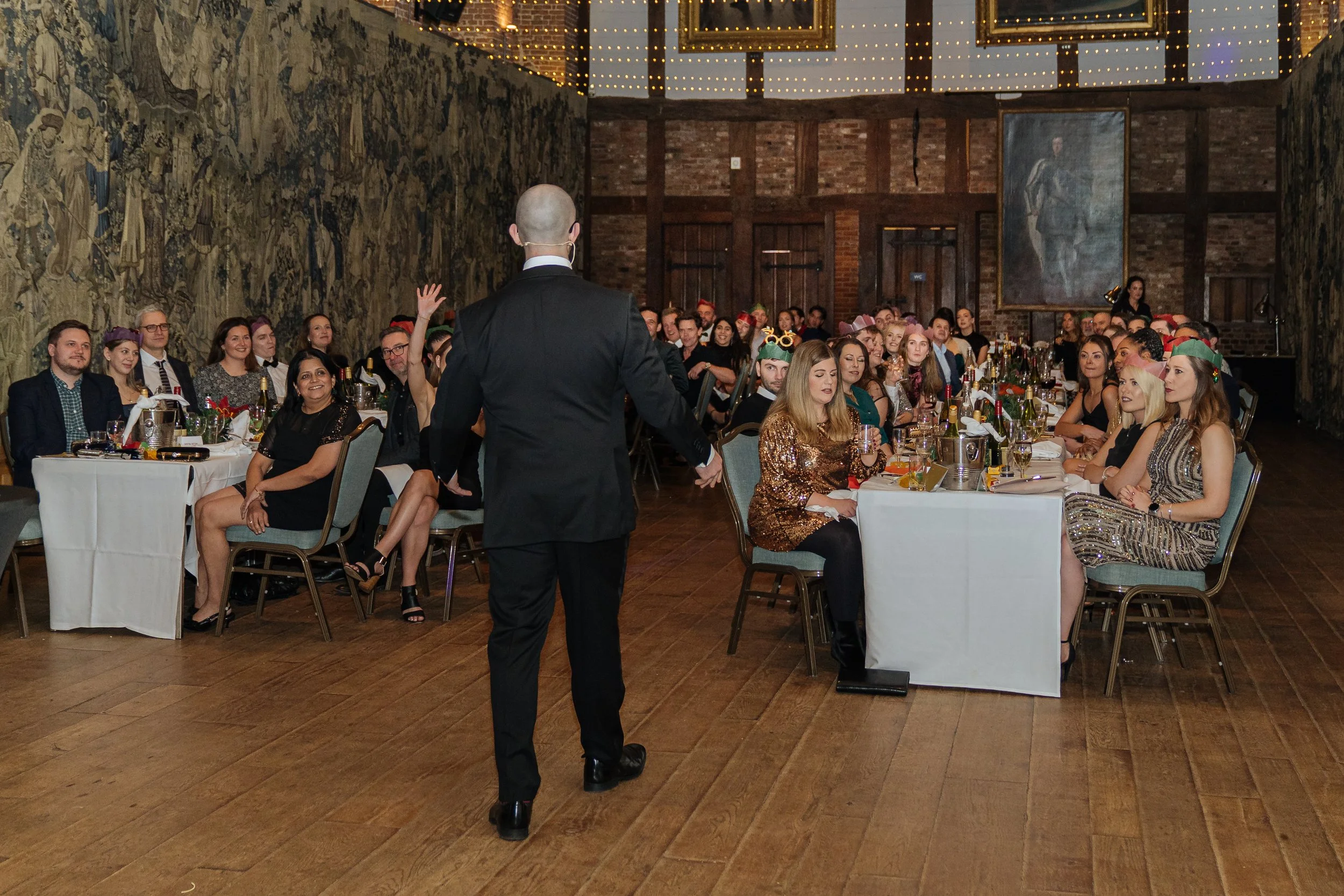 Corporate magician entertaining a full room of guests during a gala dinner.