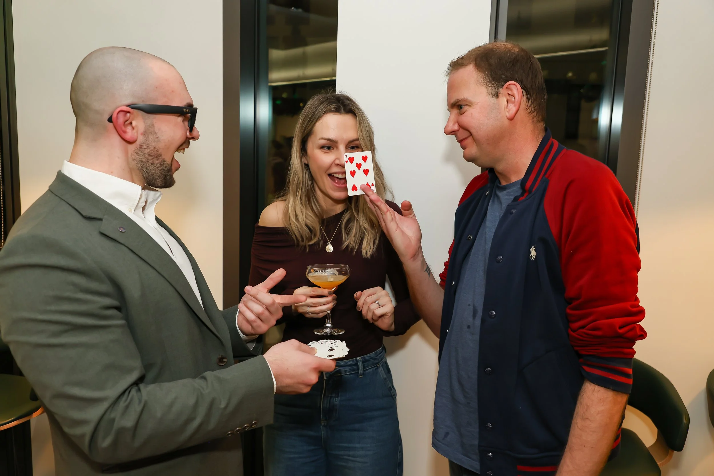 Guests enjoy impressive card tricks at a corporate reception.