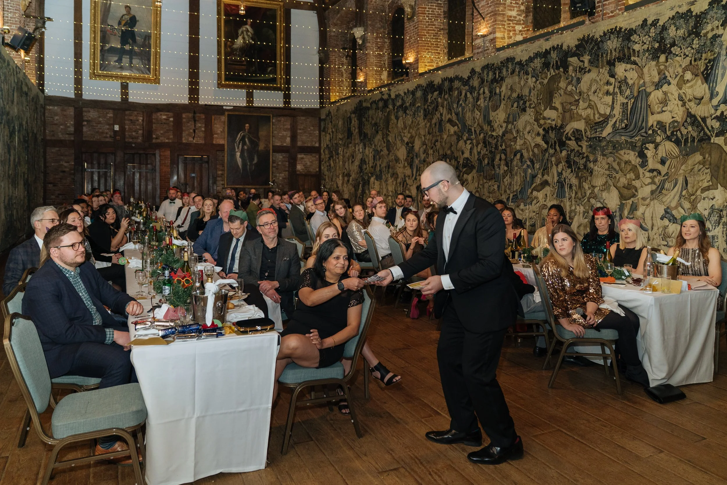 Corporate magician performing table-side magic for guests during a company gala dinner.