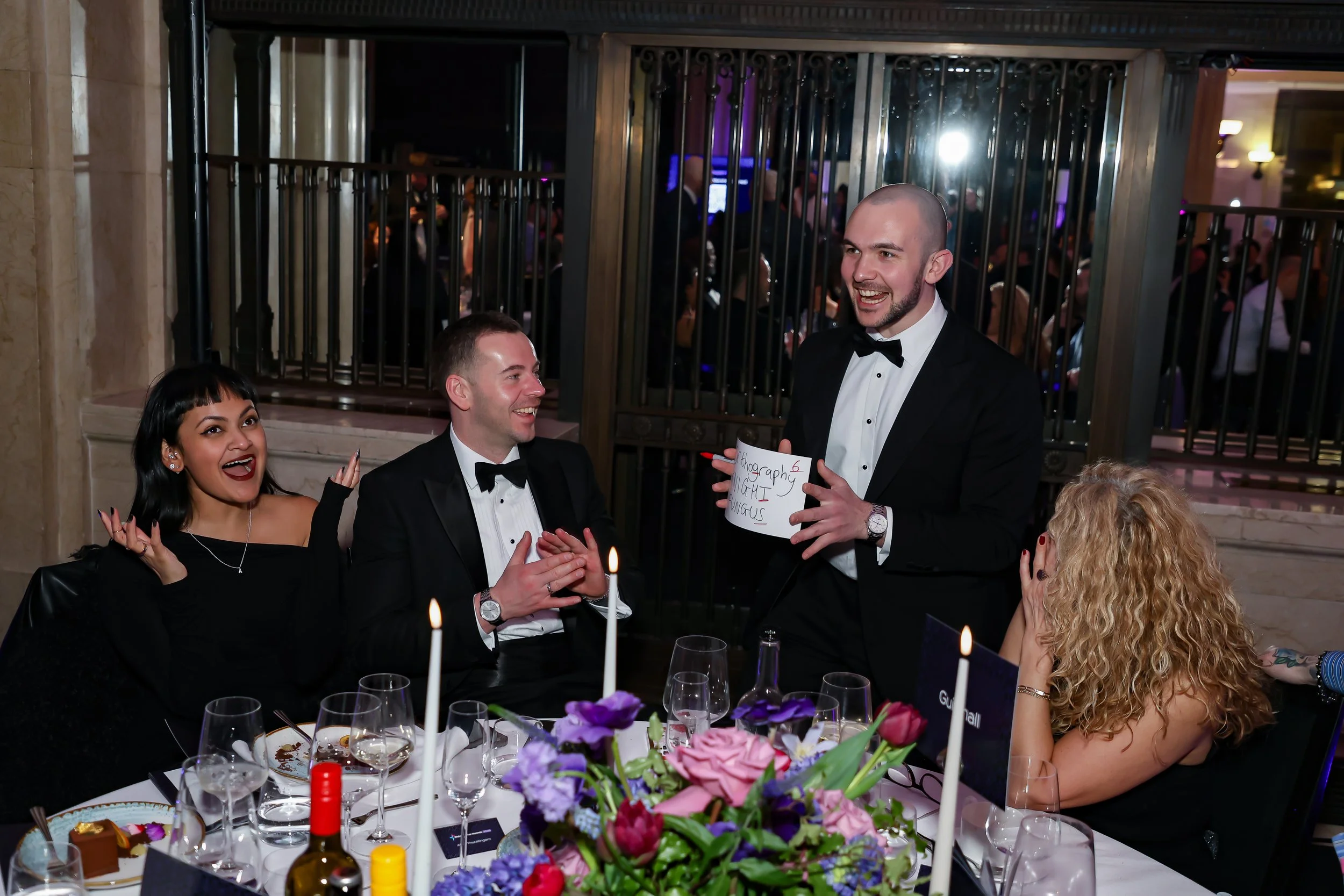 A close-up magician entertaining corporate dinner guests with hands-on magic.