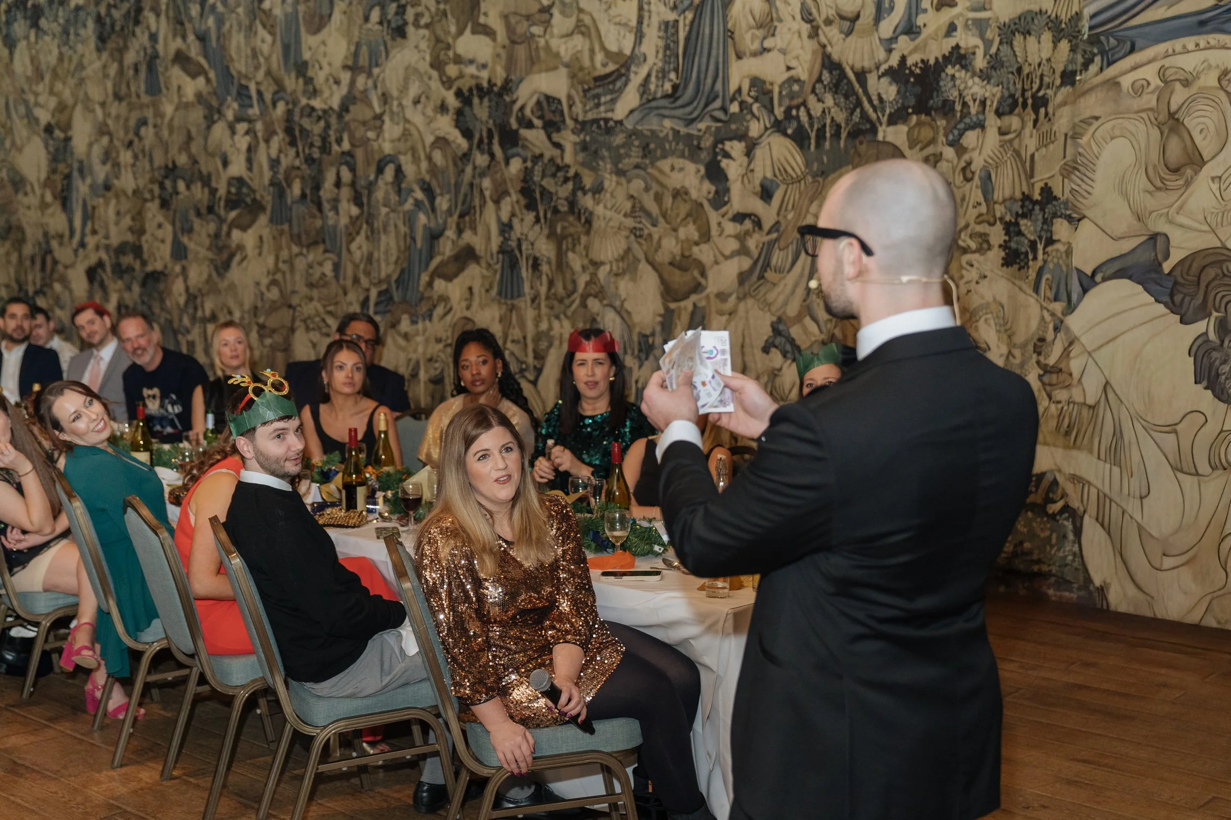 Professional magician engaging corporate attendees at a formal gala dinner event.