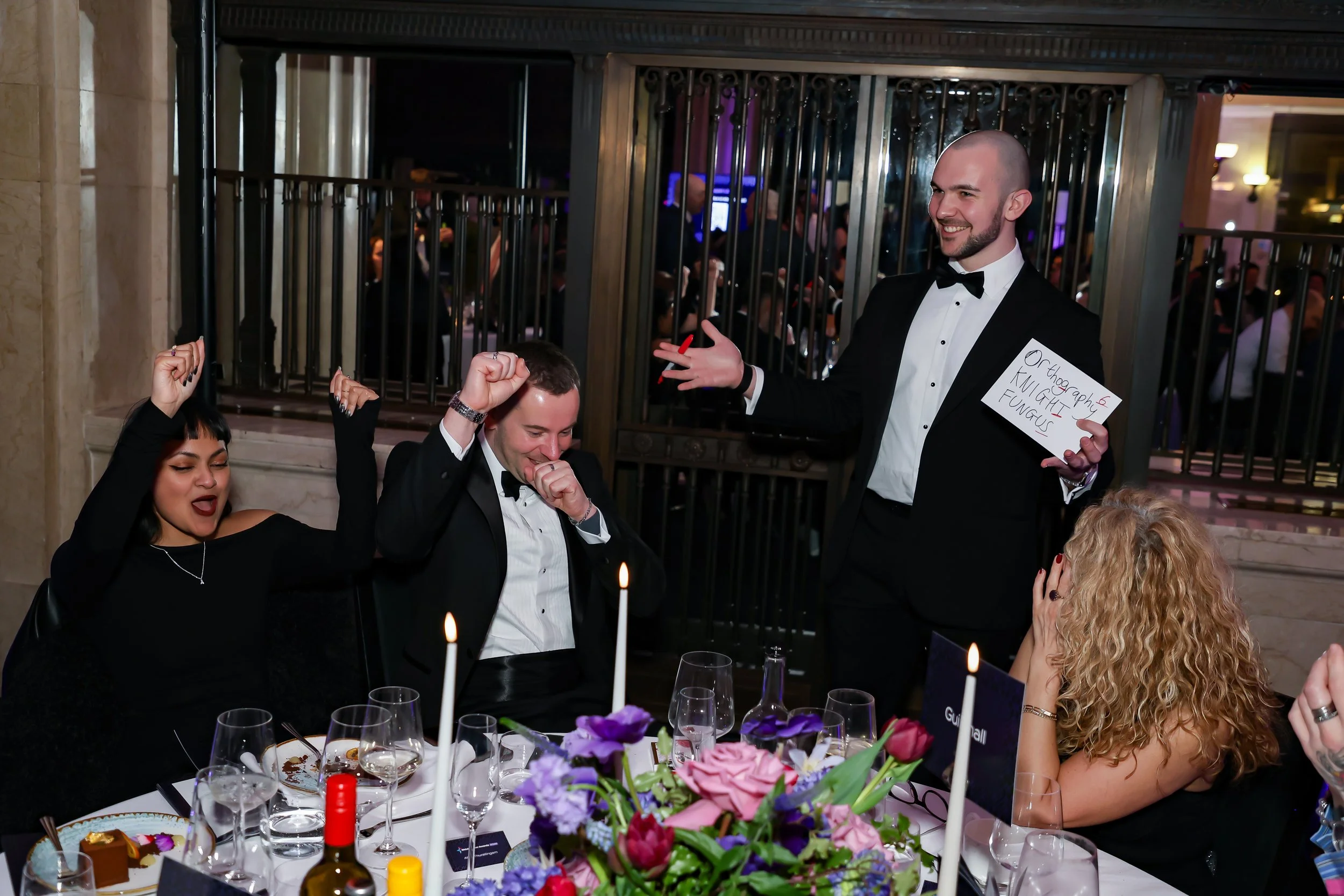 A close-up magician entertaining corporate dinner guests with hands-on magic.