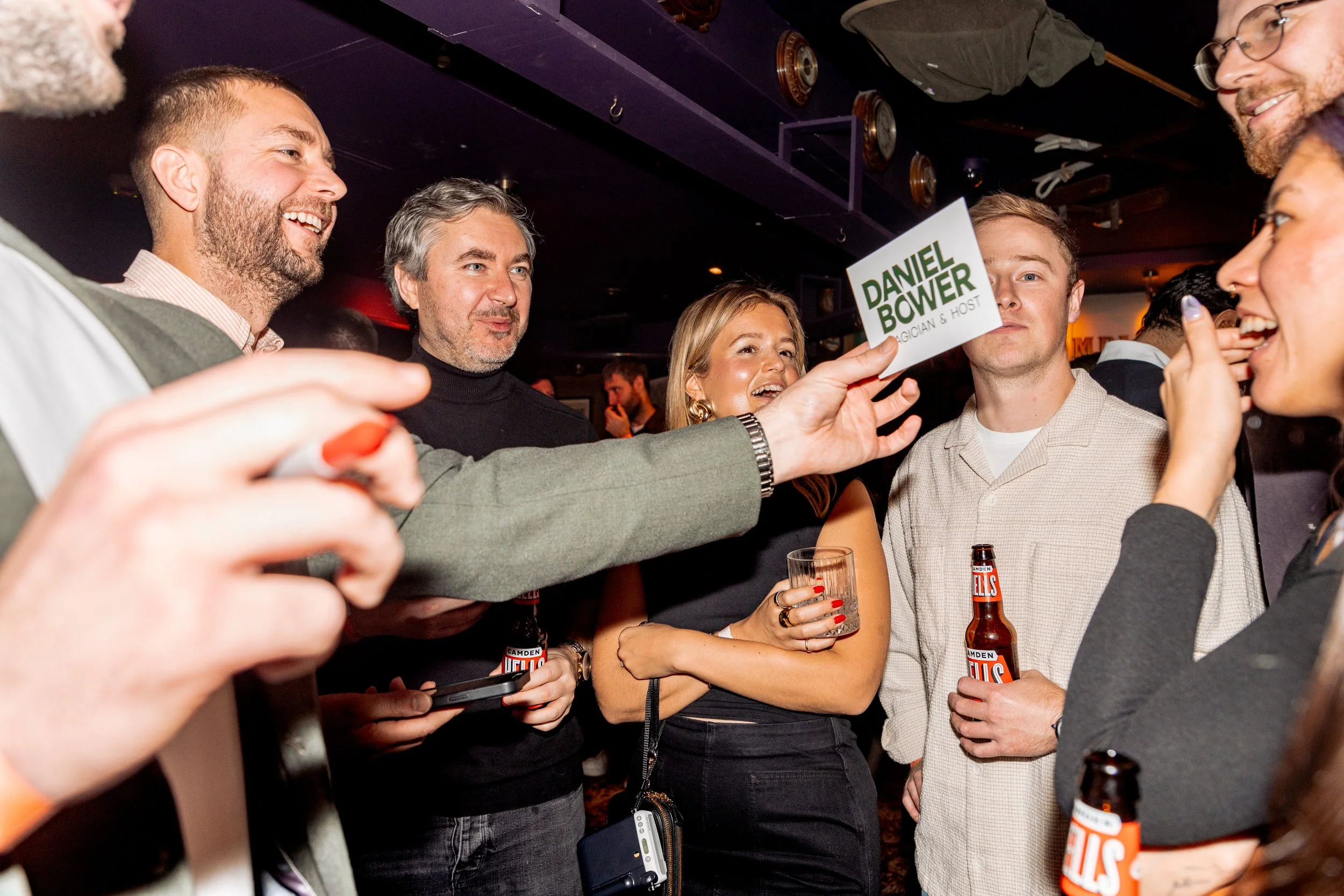 Corporate magician performing interactive card reveal for guests.