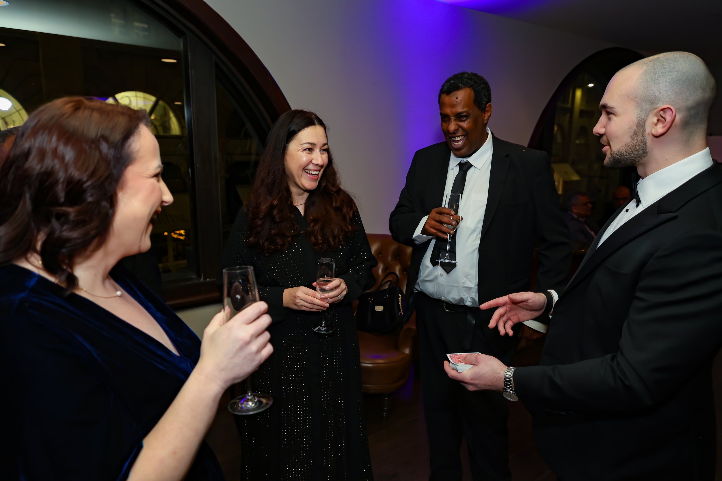 Magician engaging corporate professionals with a live card performance.
